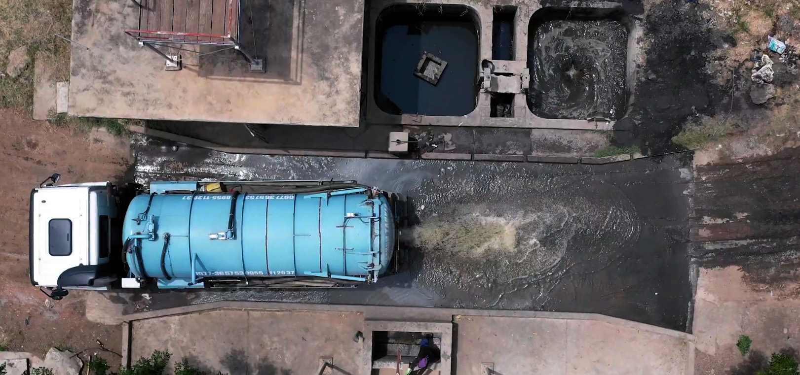 Standbild aus dem Video "Sanitärversorgung für lebenswerte Städte". Ein Tanklastwagen liefert Abwasser an einer Kläranlage ab.