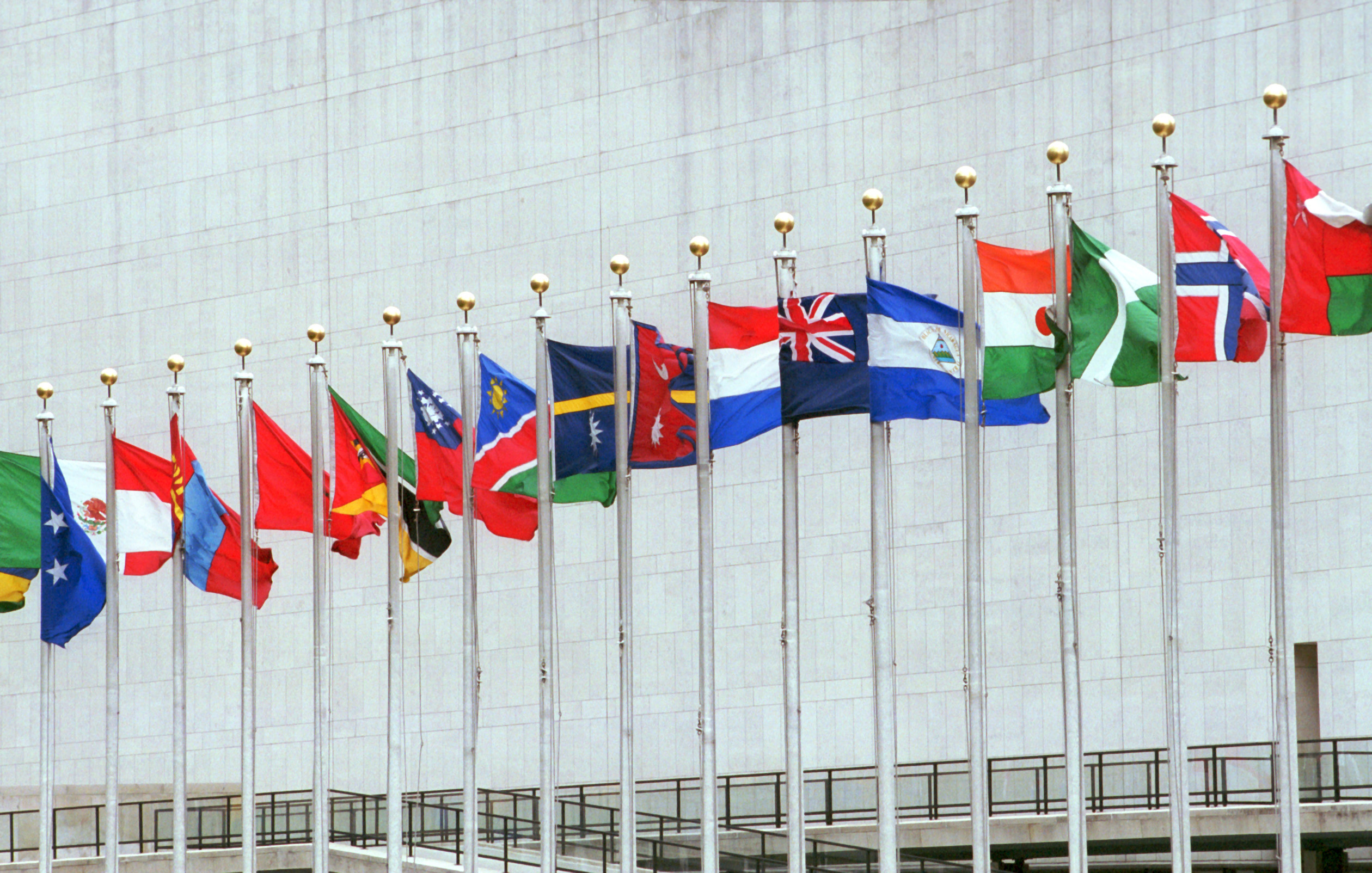 Flags of different nations in front of the main building of the United Nations.