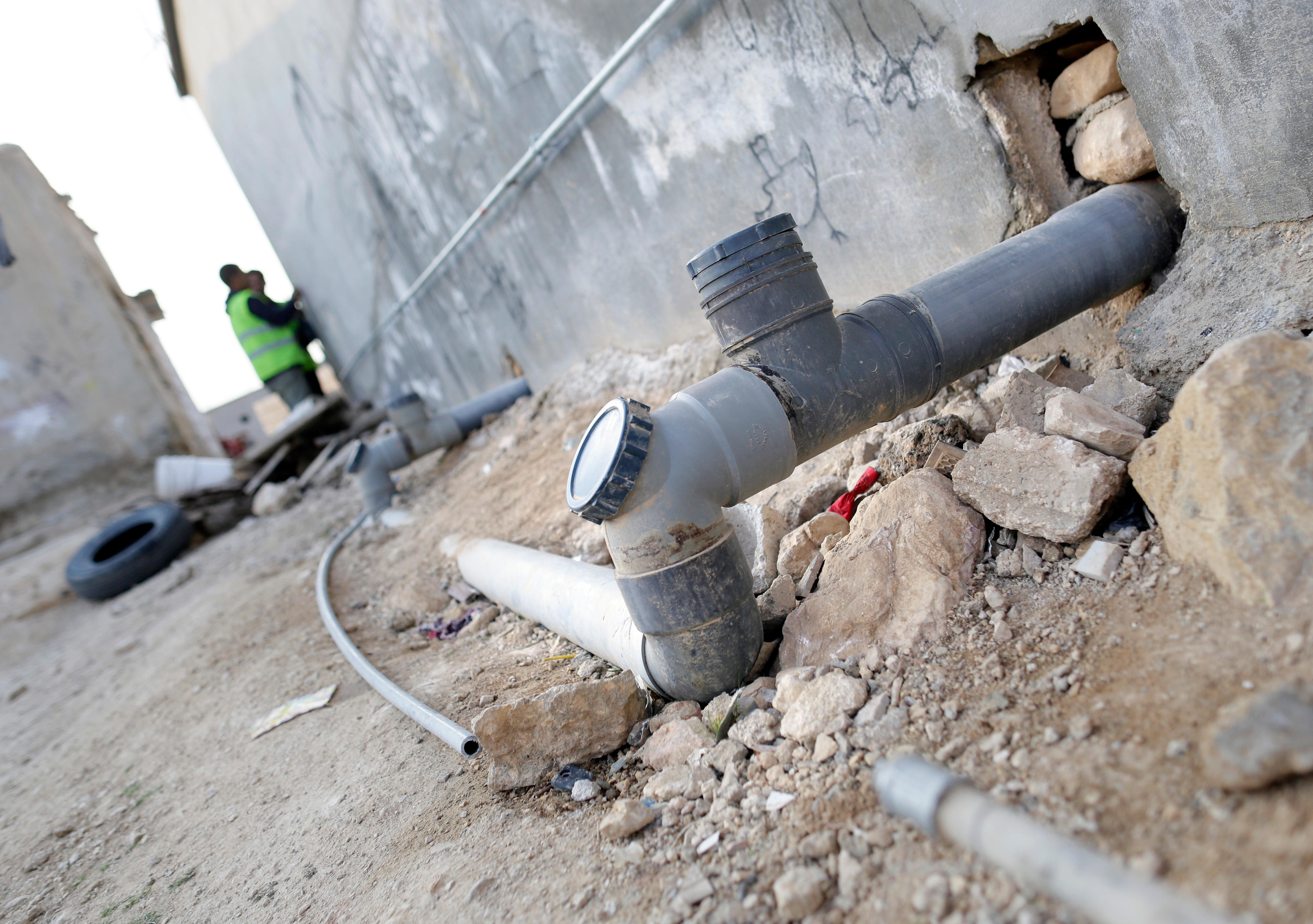 An ei­nem Haus in der Stadt Ma­fr­aq in Jorda­nien wer­den Trink- und Ab­wasser­leitungen ver­legt.