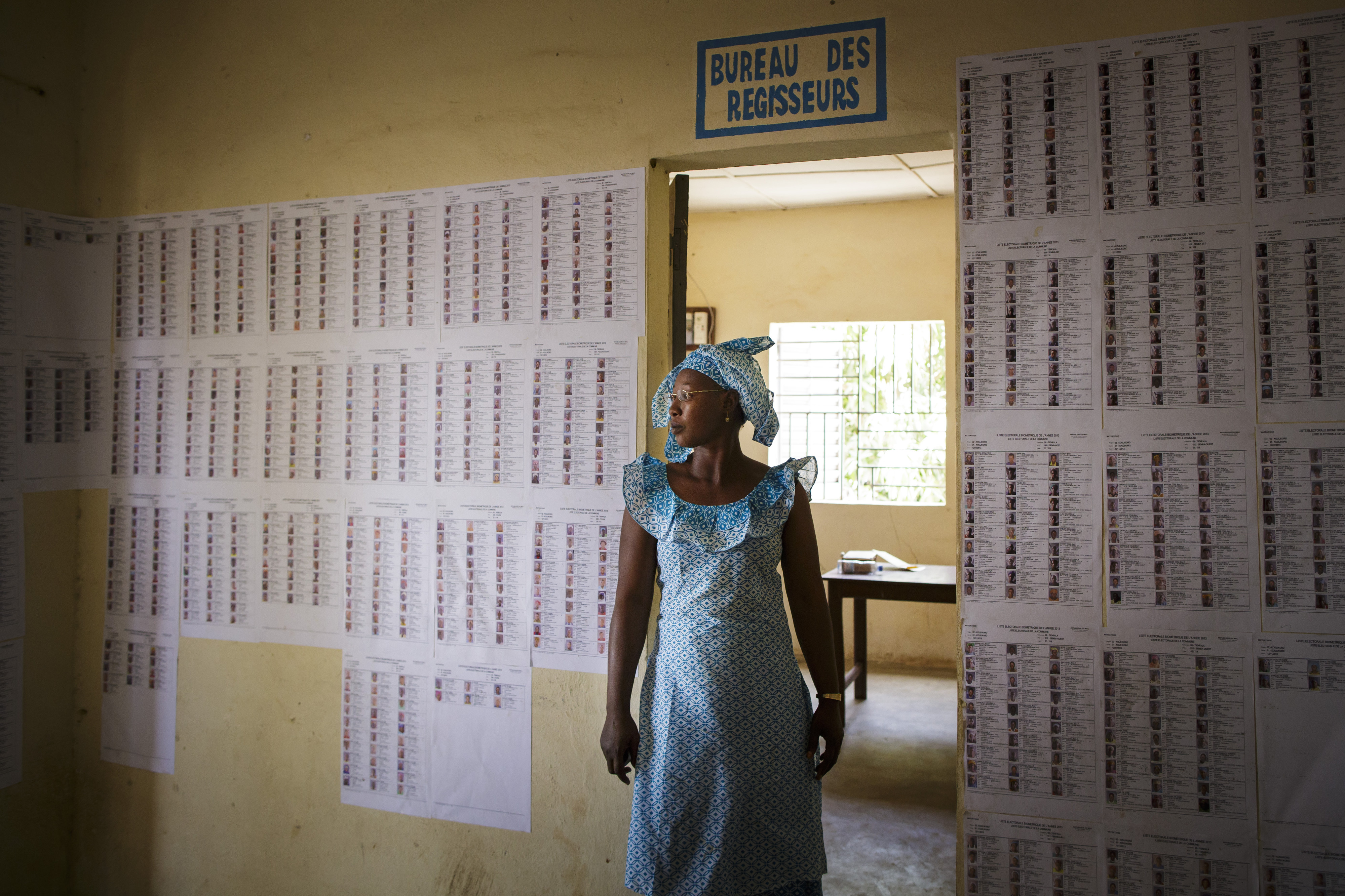 Ei­ne Frau steht in der Ge­mein­de­ver­wal­tung von Ti­en­fa­la in Mali vor Wahl­lis­ten.
