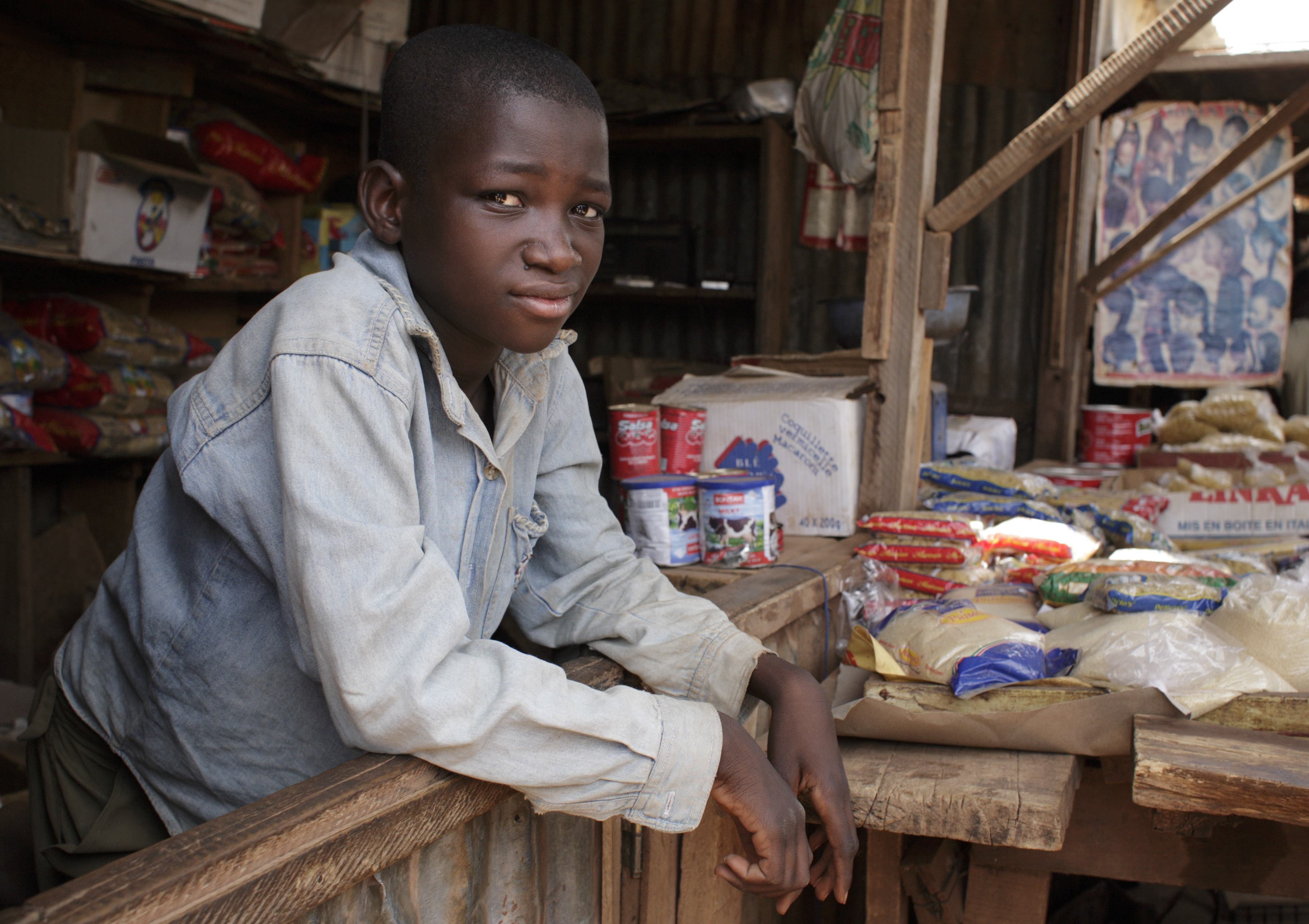 Ein Jugendlicher arbeitet in Burkina Faso an einem Marktstand.