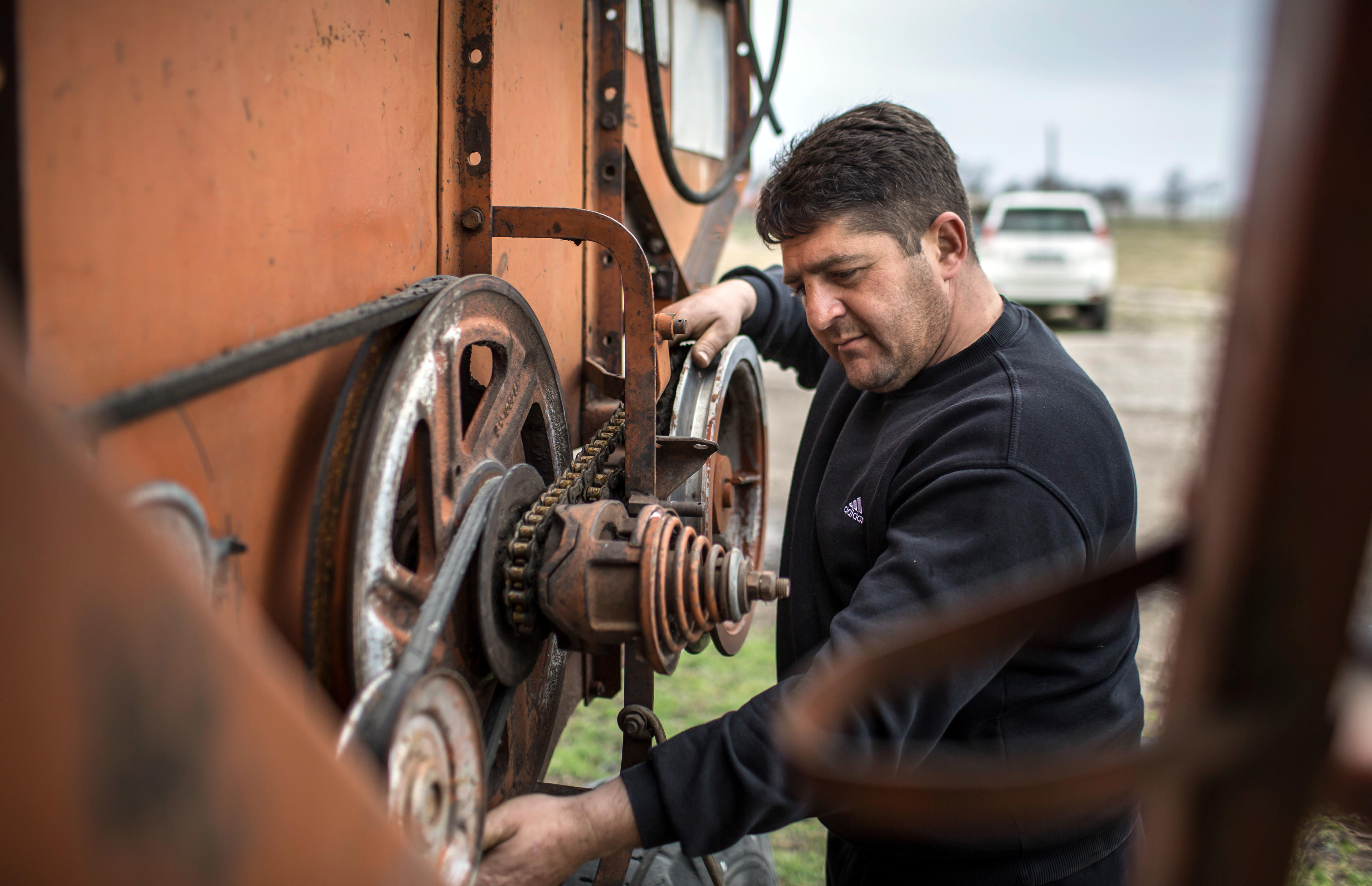 Georgia: A farmer repairing a combine harvester
