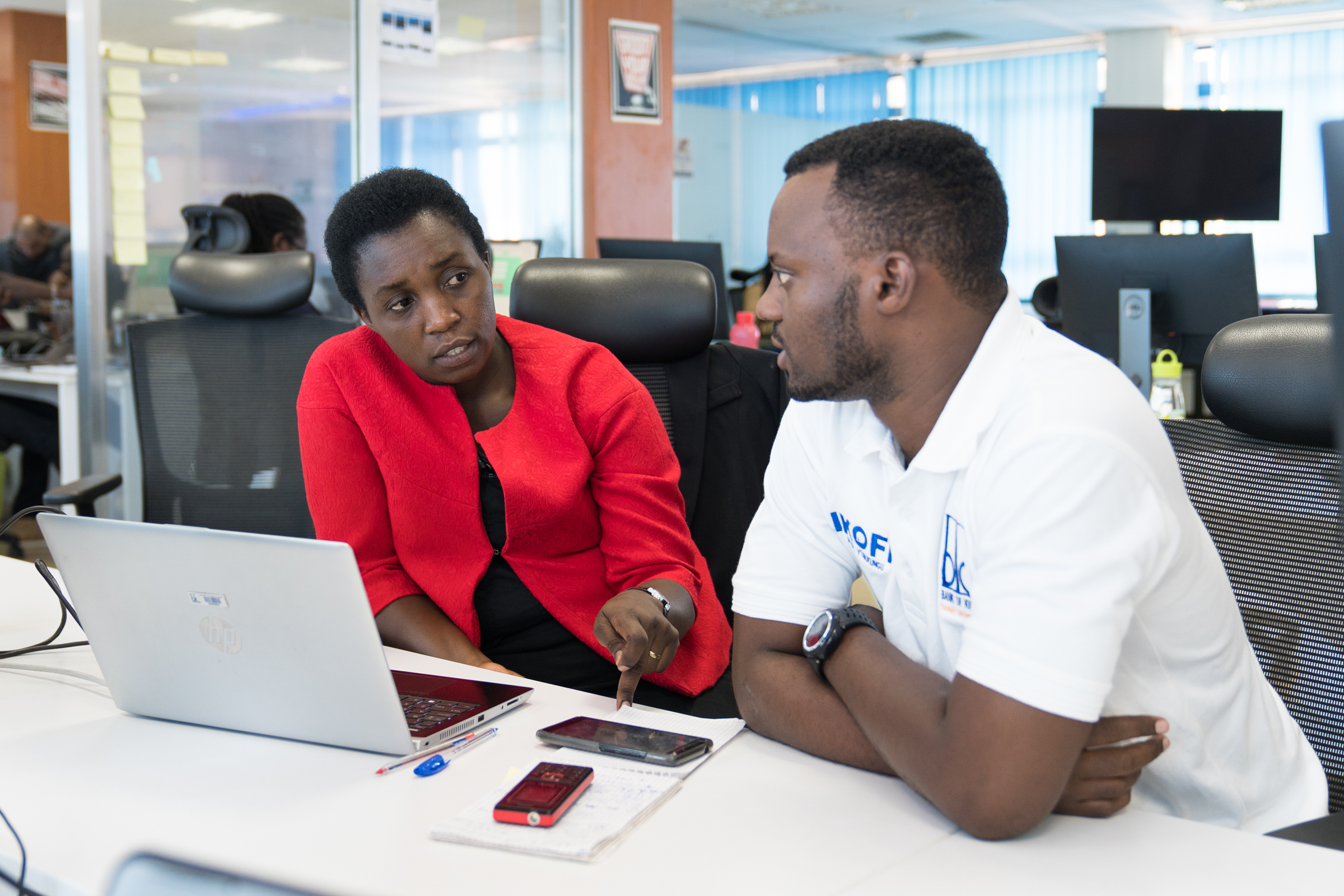 Informatikerin Clothilde Uwineza aus Ruanda im Gespräch mit einem Kollegen am Arbeitsplatz