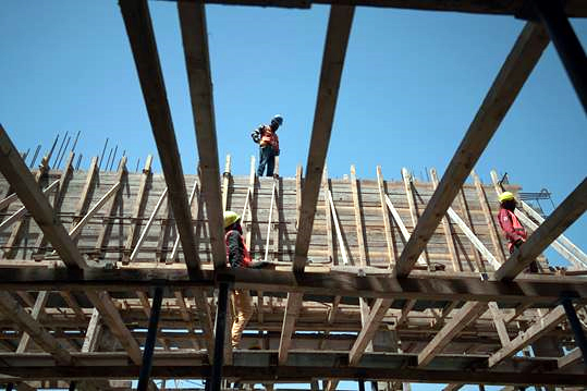 Wiederaufbau des Gerichtsgebäudes in Mossul: Drei Bauarbeiter auf einer Baustelle
