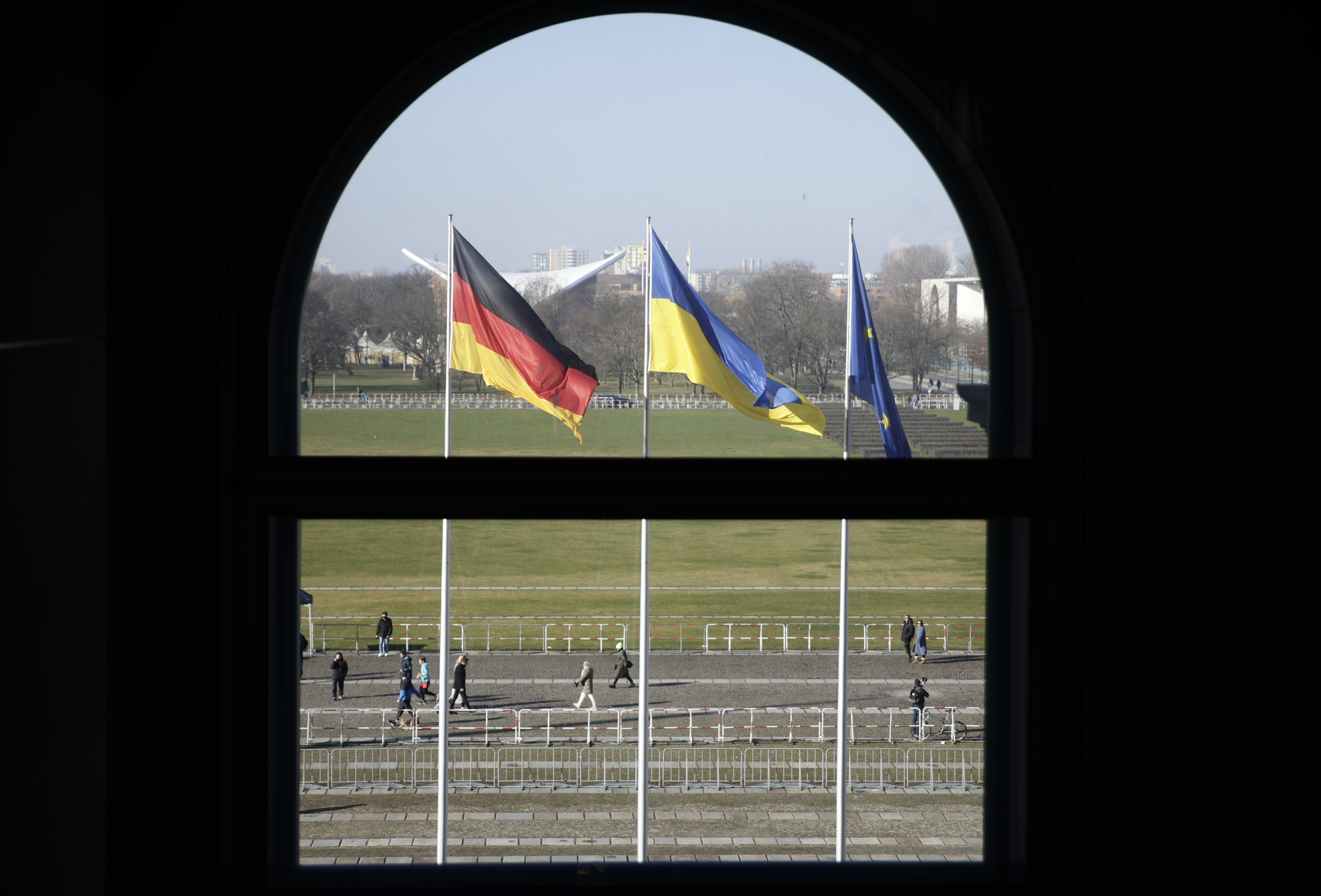 Symbolbild: Die Flaggen von Deutschland, der Ukraine und der Europäischen Union aufgenommen durch ein Fenster des Reichstagsgebäudes in Berlin