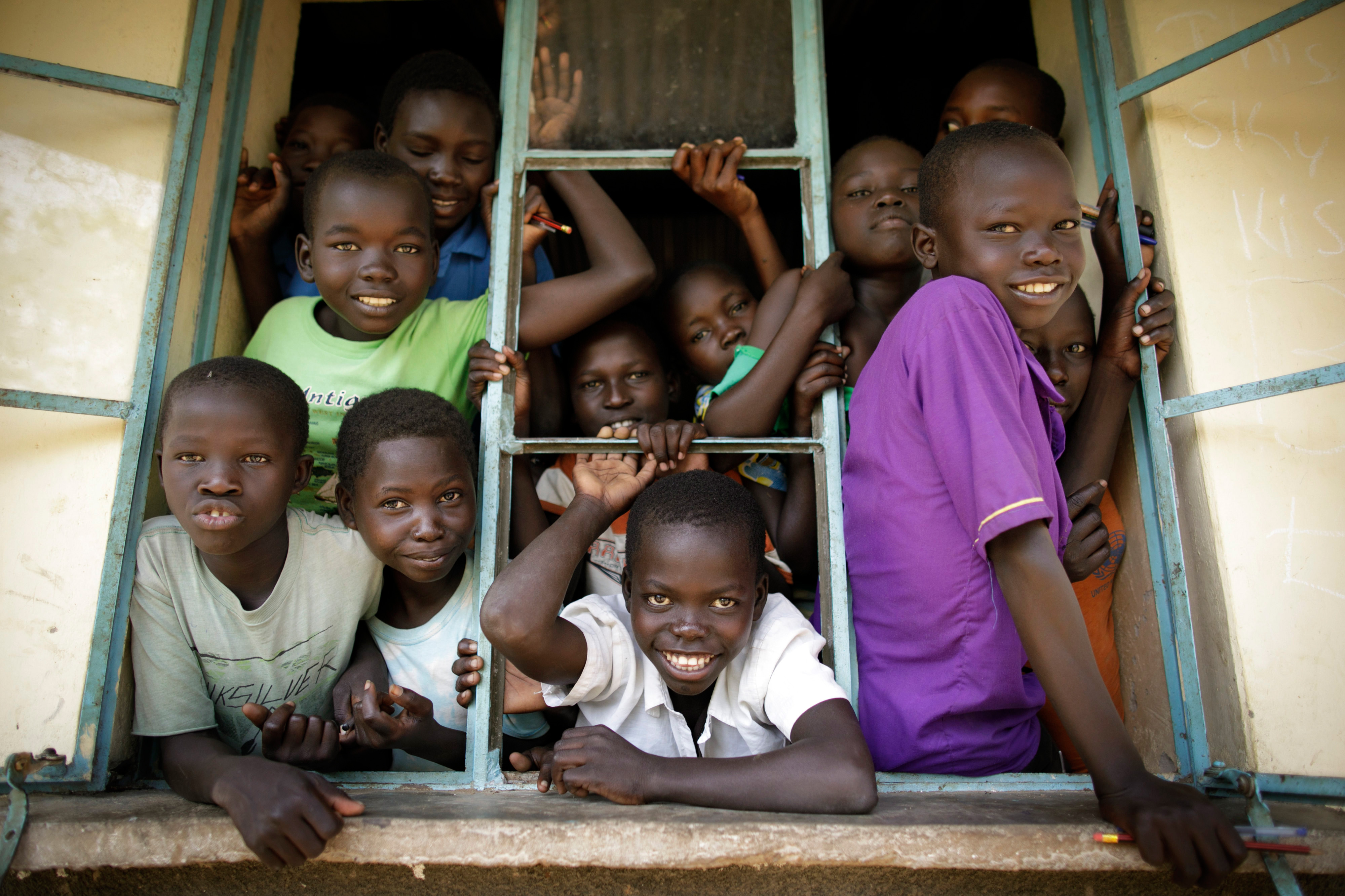 Schueler schauen aus einem offenen Fenster einer Schule im Rhino Refugee Camp Settlement im Norden Ugandas. Hier werden Kinder von Einheimischen und Fluechtlingen gemeinsam unterrichtet. In dem Gebiet leben rund 90.000 Fluechtlinge aus dem Suedsudan,