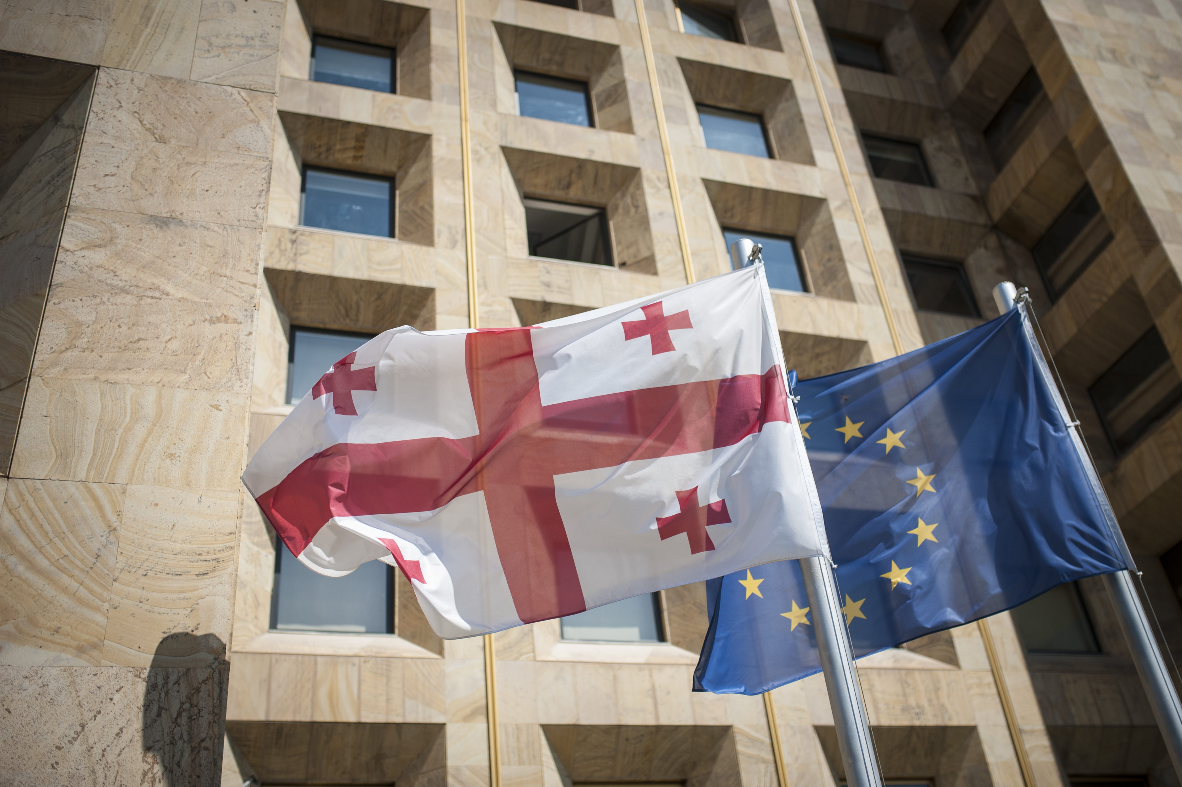 Fahnen von Georgien und der Europäischen Union wehen vor der Regierungskanzlei in Tiflis, Georgien.