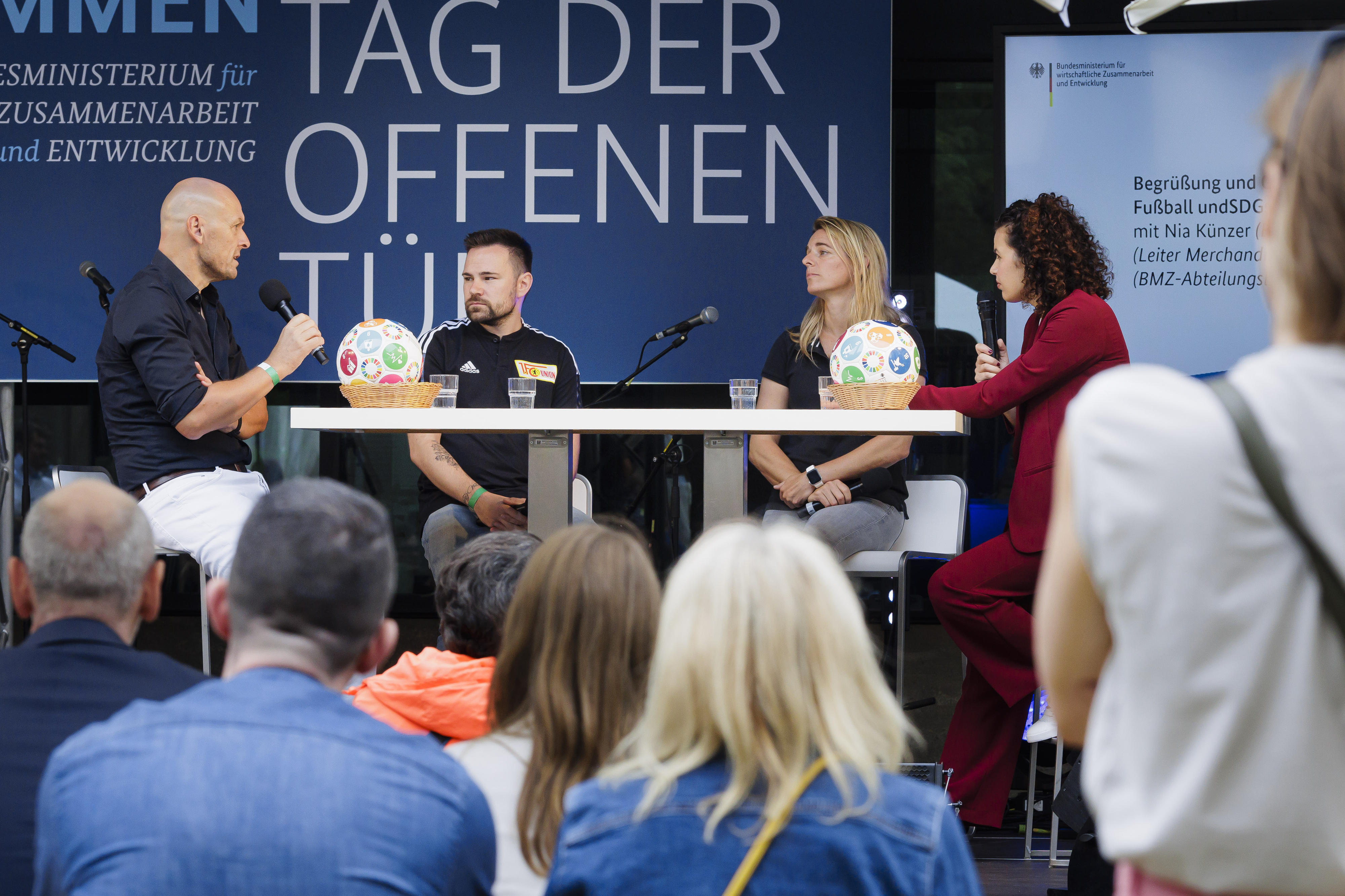 BMZ-Abteilungsleiter Dirk Meyer im Gespräch mit Nia Künzer (BMZ-Sport-Botschafterin) und Gordon Knebel (Leiter Merchandising, 1. FC Union Berlin)