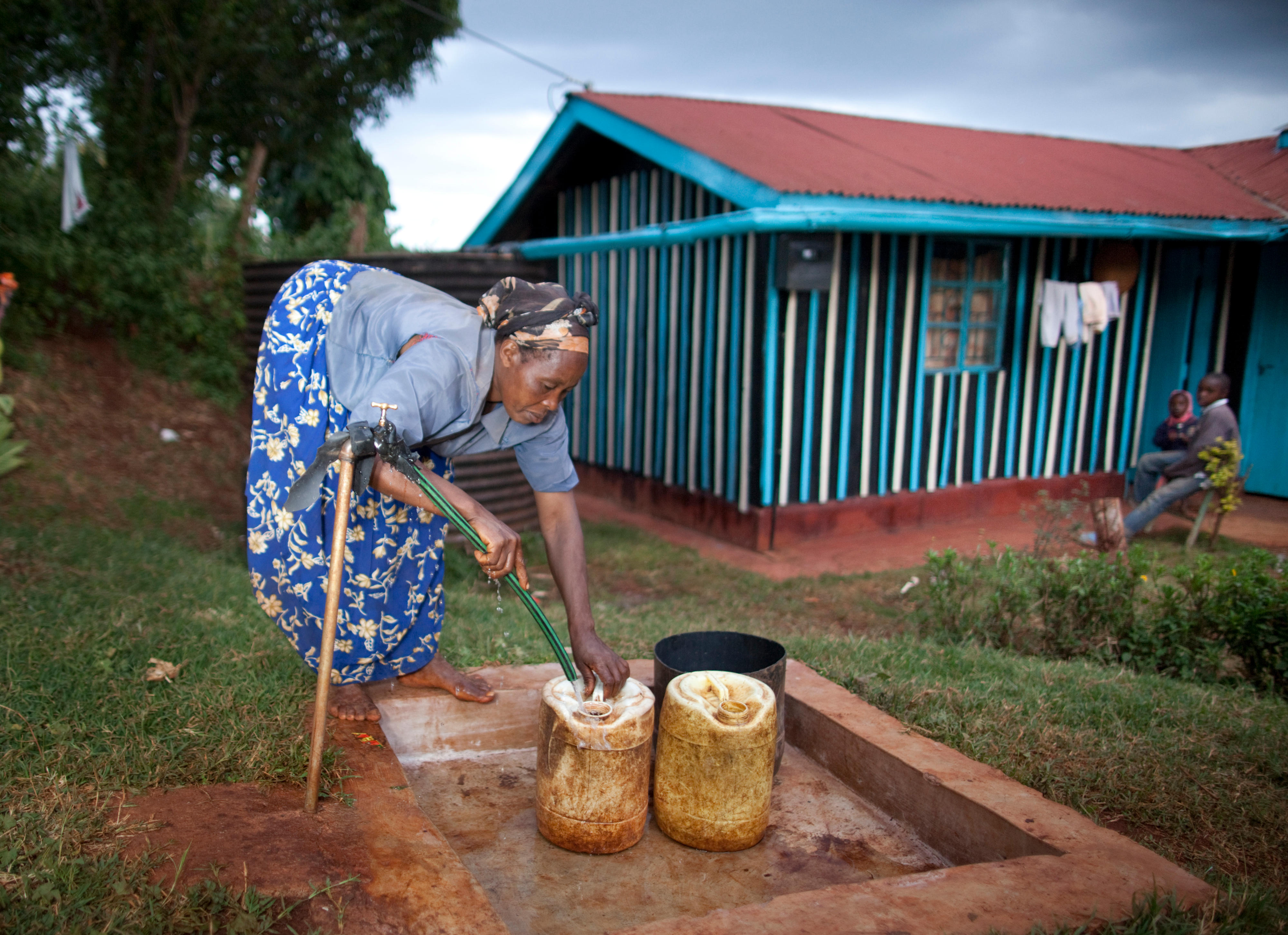 Kikuyu-Frau, deren Haus an die städtische Wasserversorgung angeschlossen ist 