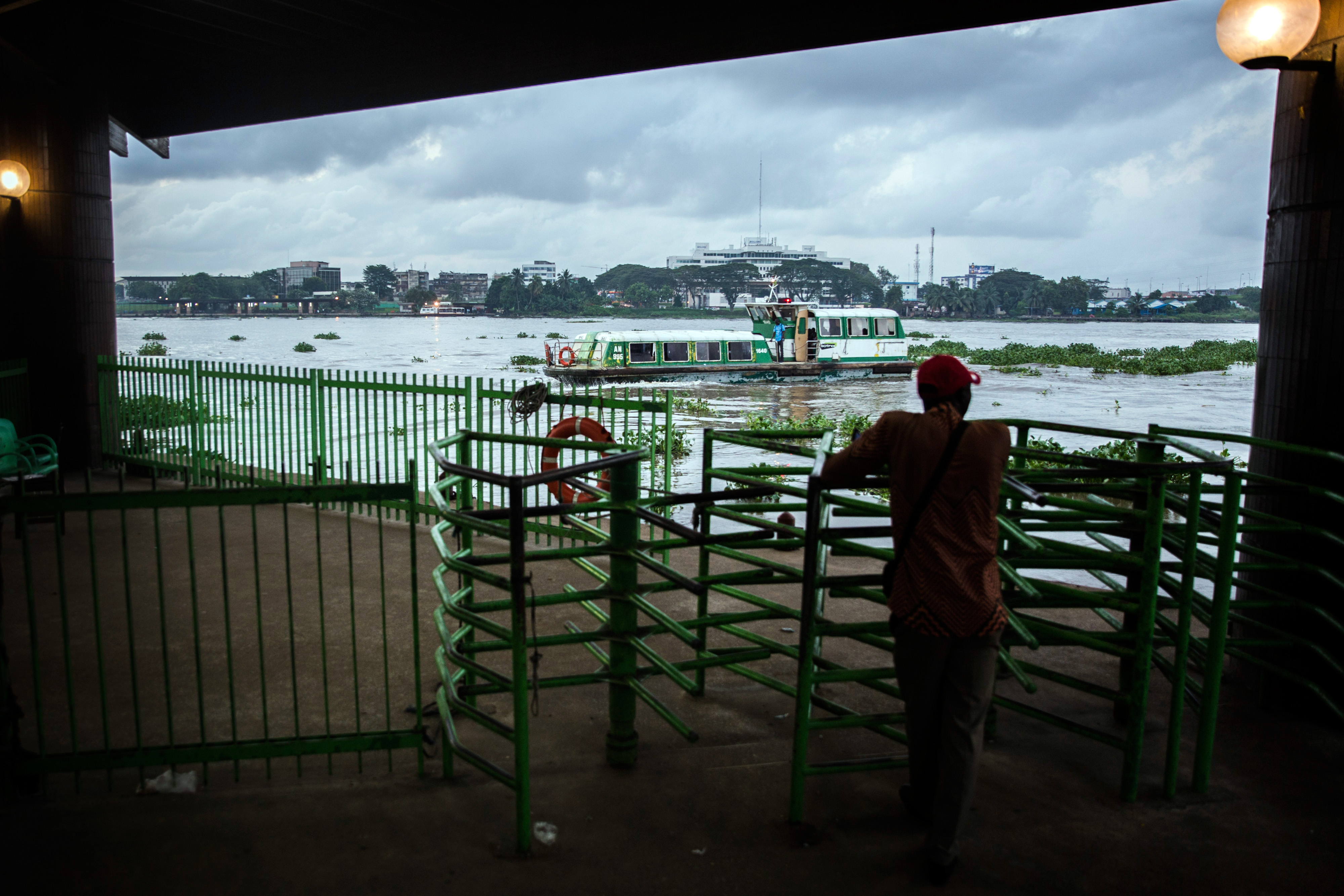Ein Mann wartet auf eine Fähre an der Lagune Ebrie in Abidjan , Côte d’Ivoire.