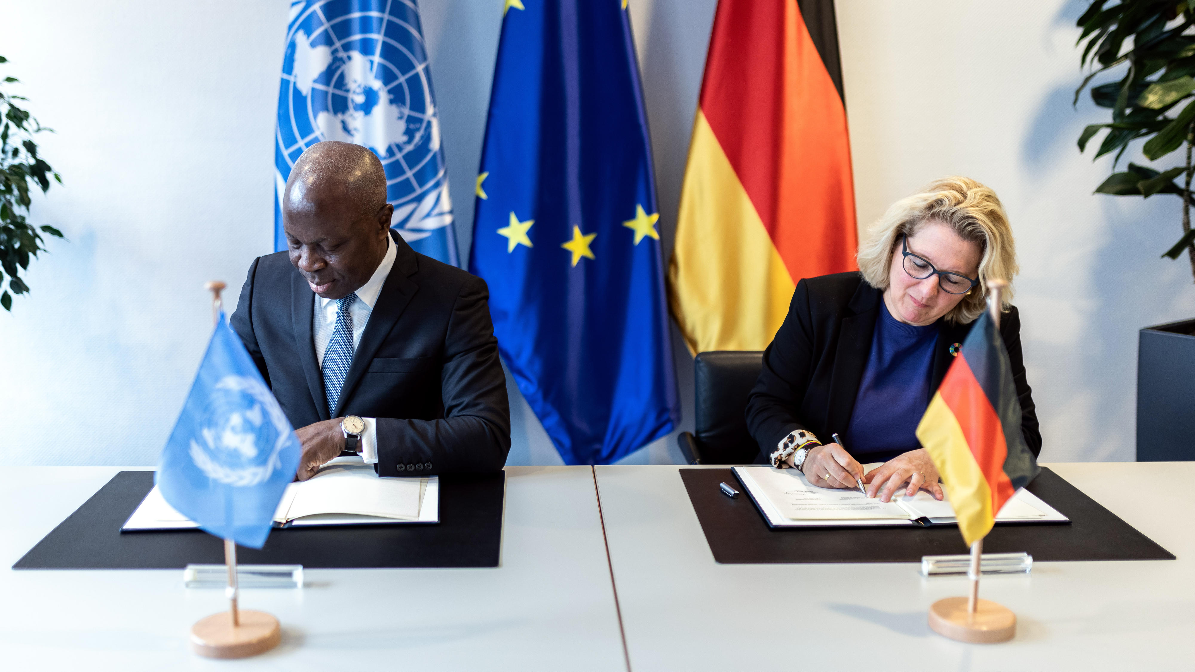 Gilbert Houngbo, Generaldirektor der ILO, und Bundesentwicklungsministerin Svenja Schulze bei der Unterzeichnung einer Vereinbarung über eine noch engere partnerschaftliche Zusammenarbeit des BMZ mit der ILO