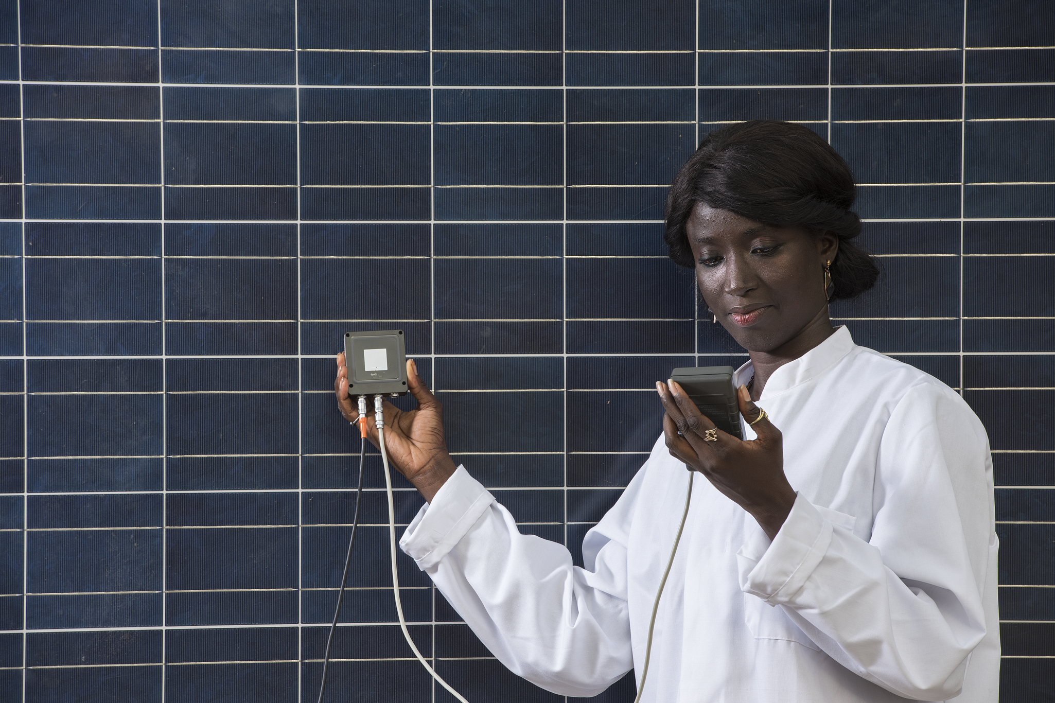 La­mi­ne Ba­ra Dia­gne prüft ei­nen di­gi­ta­len Ther­mo­me­ter­füh­ler.
