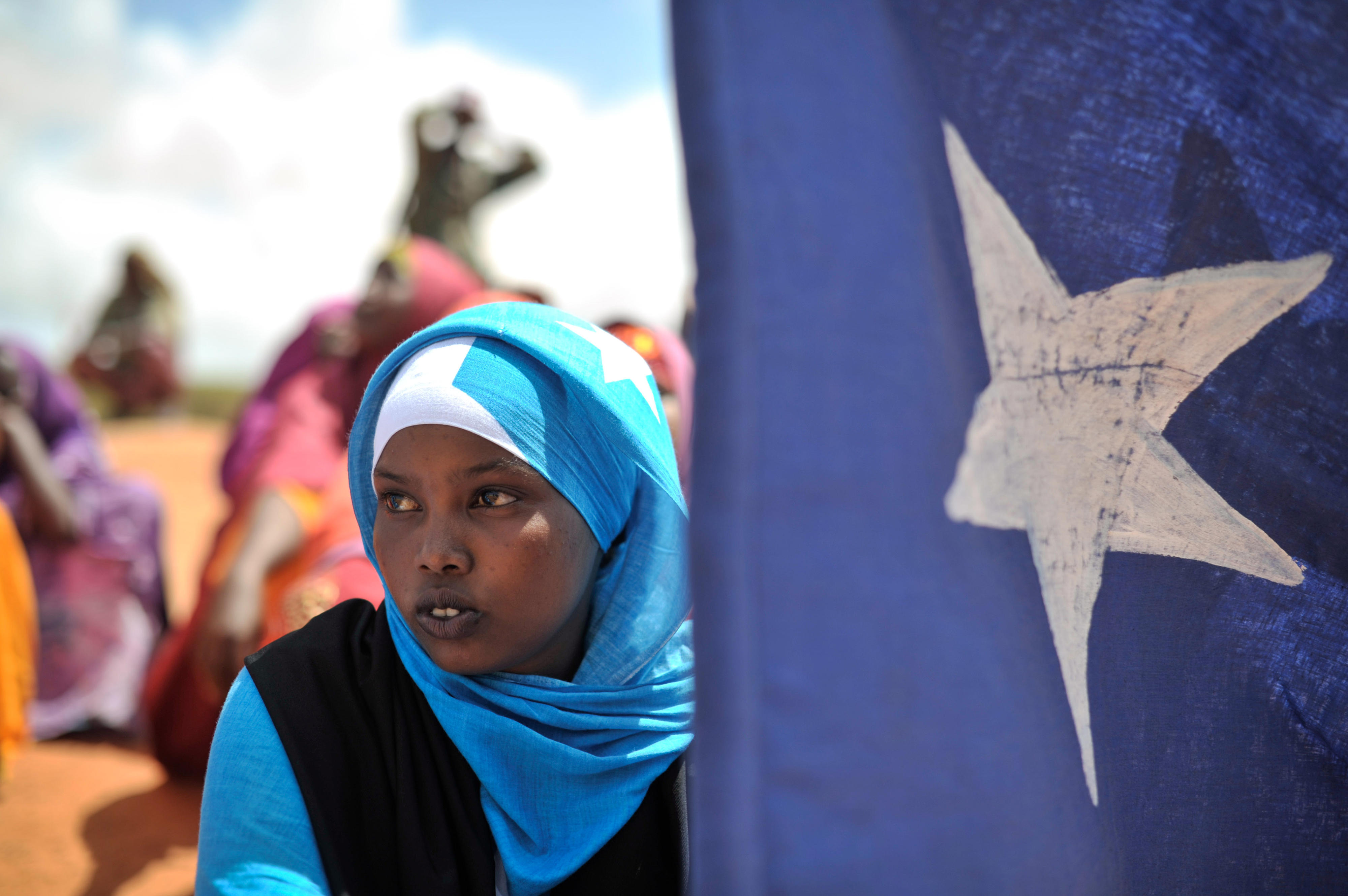 A young woman with a Somali flag during a demonstration in Marka, Somalia