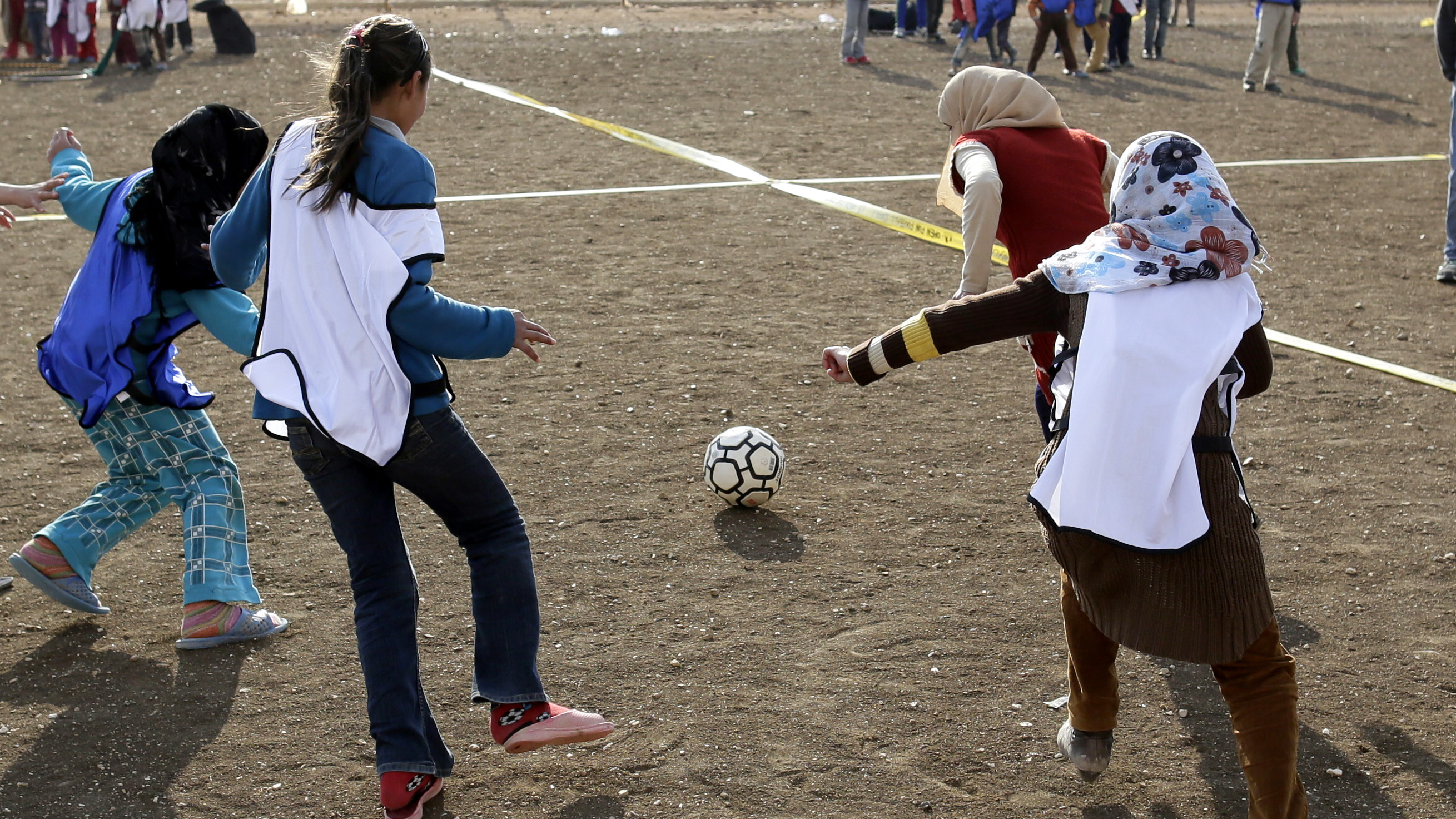 Syrian girls playing football in a refugee camp in Jordan.