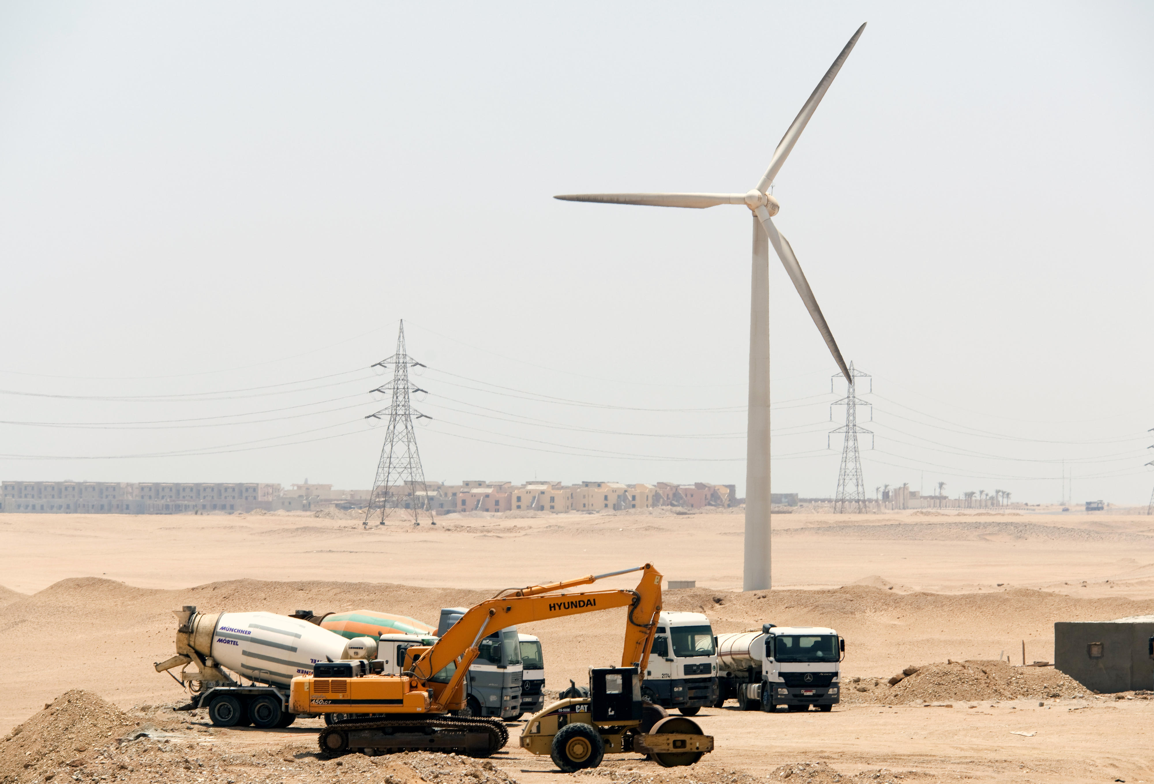 Construction site vehicles in front of a wind turbine in Egypt