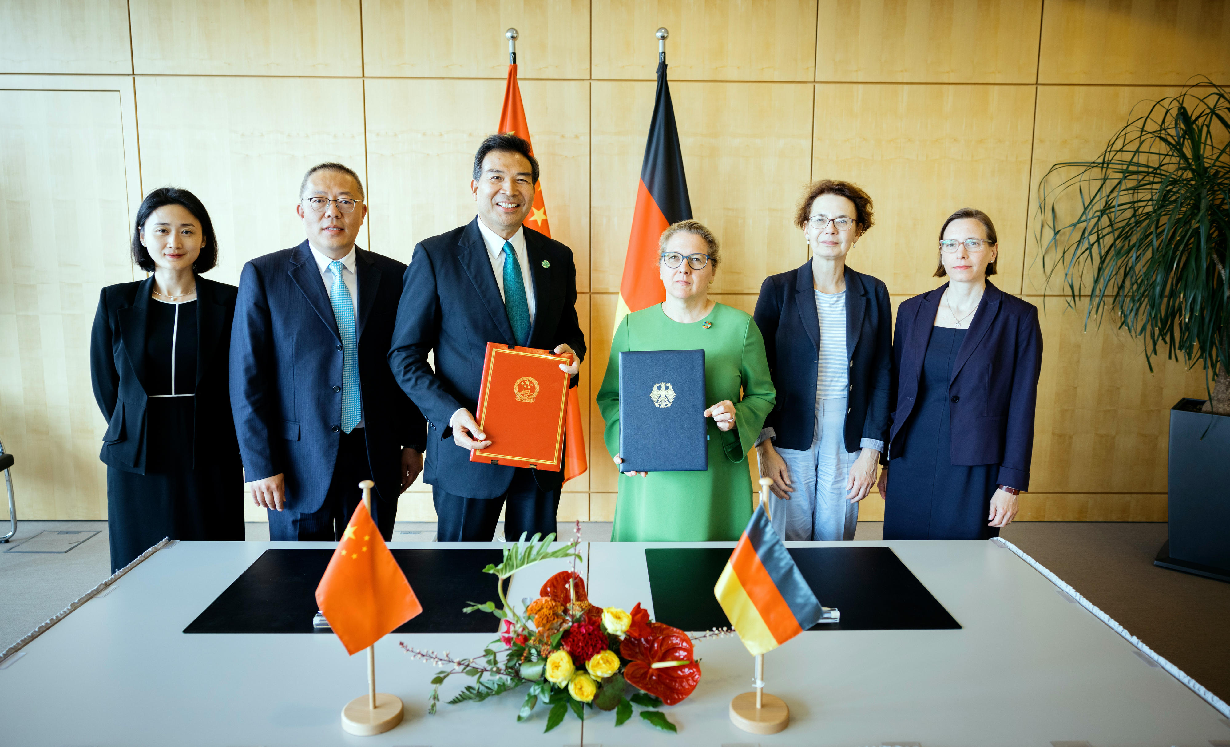 Entwicklungsministerin Svenja Schulze und Luo Zhaohui, Vorsitzenden der chinesischen Entwicklungsagentur CIDCA sowie Mitglieder der deutschen und chinesischen Delegation bei der Unterzeichnung des gemeinsamen Aktionsplans in Berlin