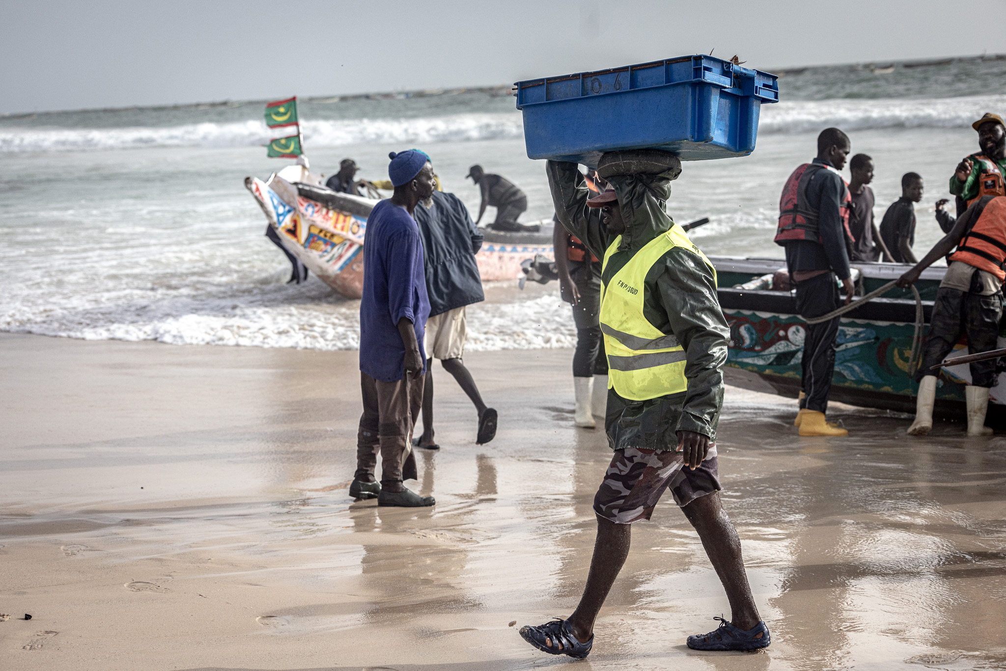 Ein Mitarbeiter der mauretanischen Küstenwache bringt eine Kiste voll Fisch zur Inspektion. 