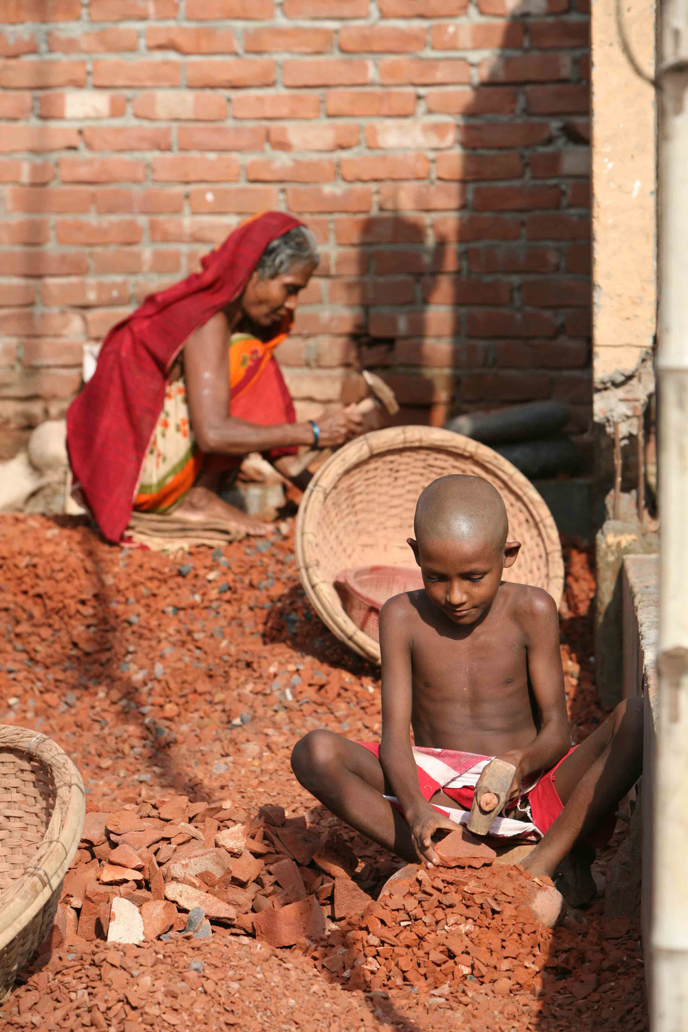 Ein Junge in Dhaka in Bangladesch stellt Backsteine her.