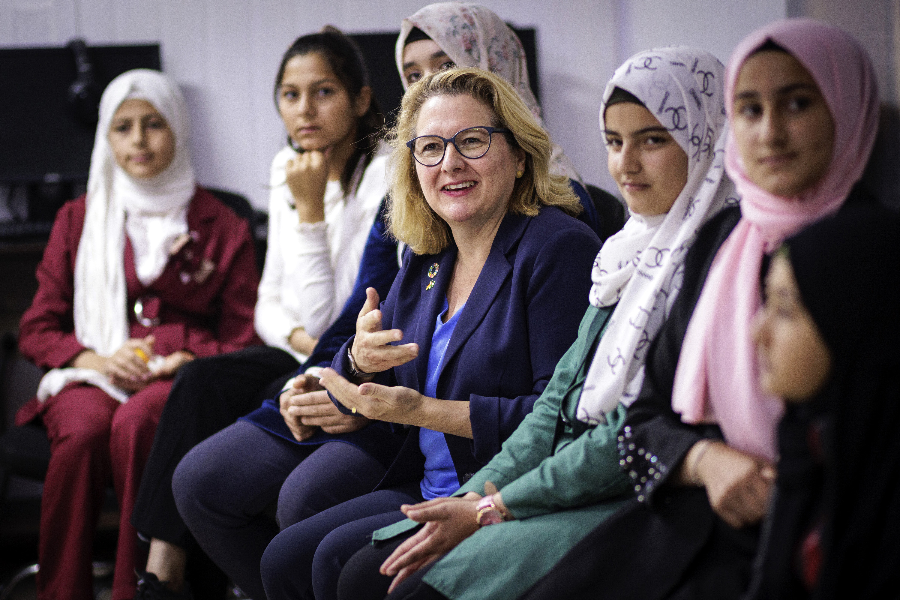 Ministerin Schulze im Gespräch mit jungen Frauen beim Besuch des Saturn-Makani-Zentrums im Flüchtlingscamp Zaatari.