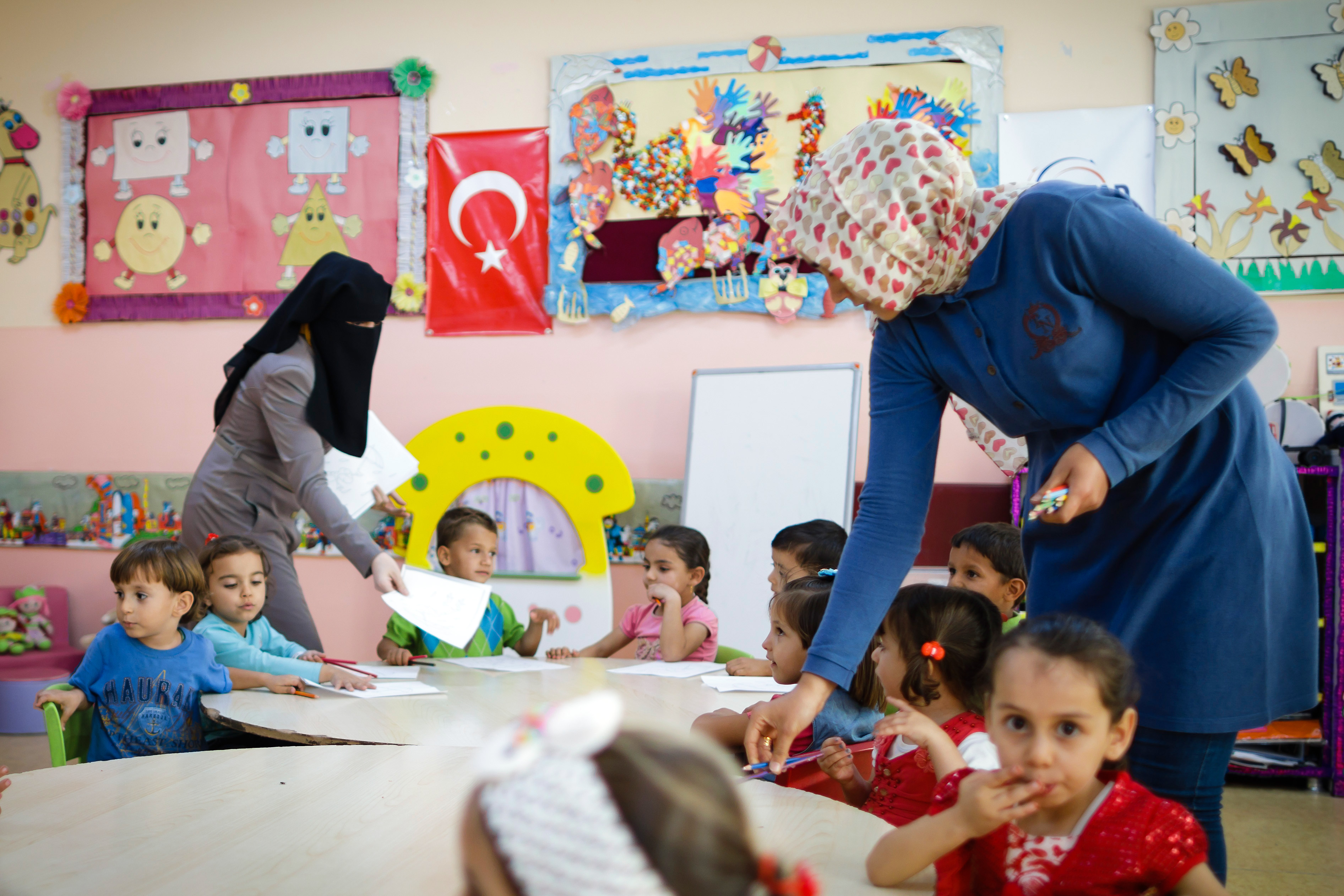 Two teachers teaching Syrian children at a preschool in a refugee camp in Turkey