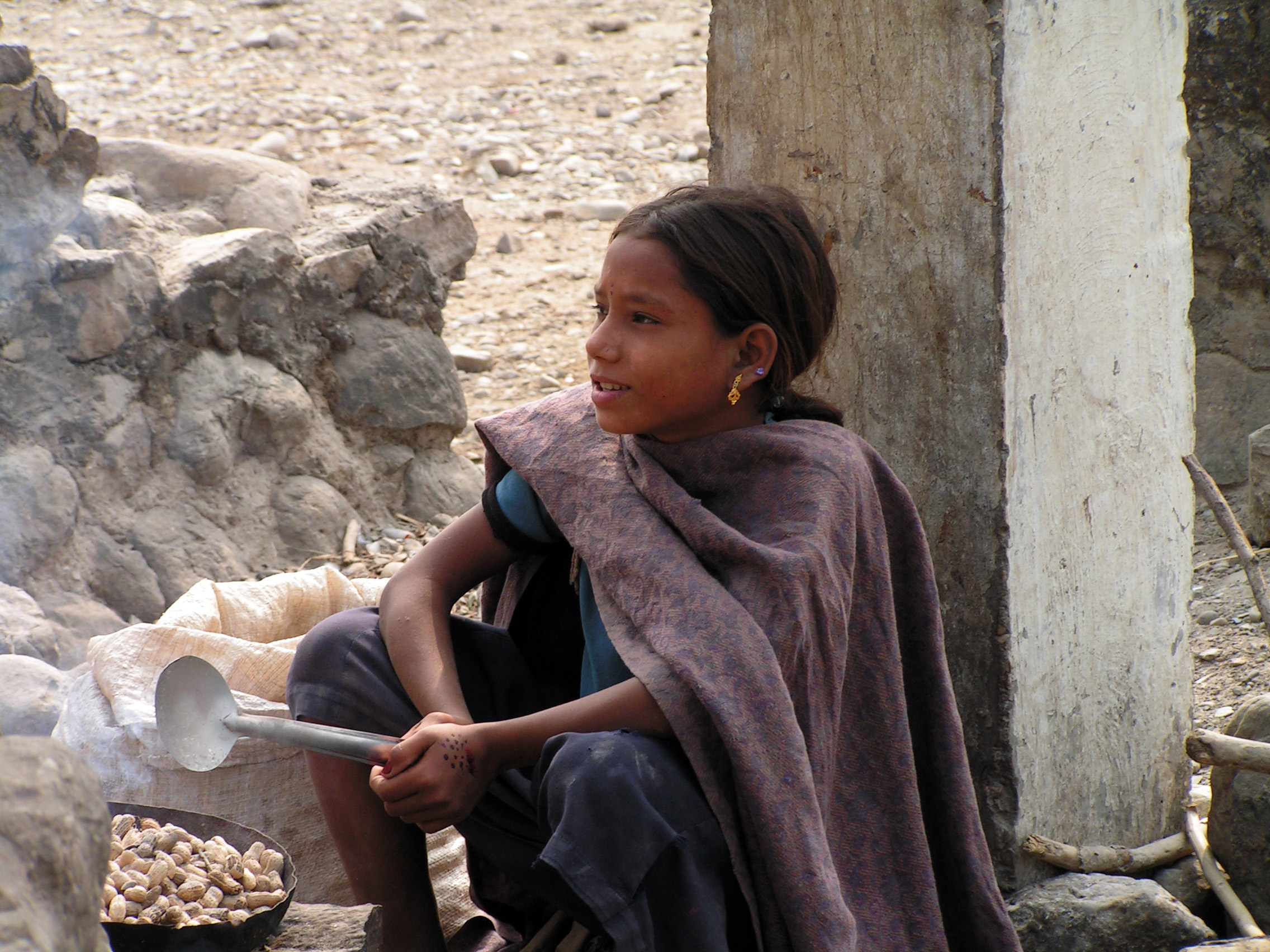 Ein nepalisches Mädchen kocht Erdnüsse