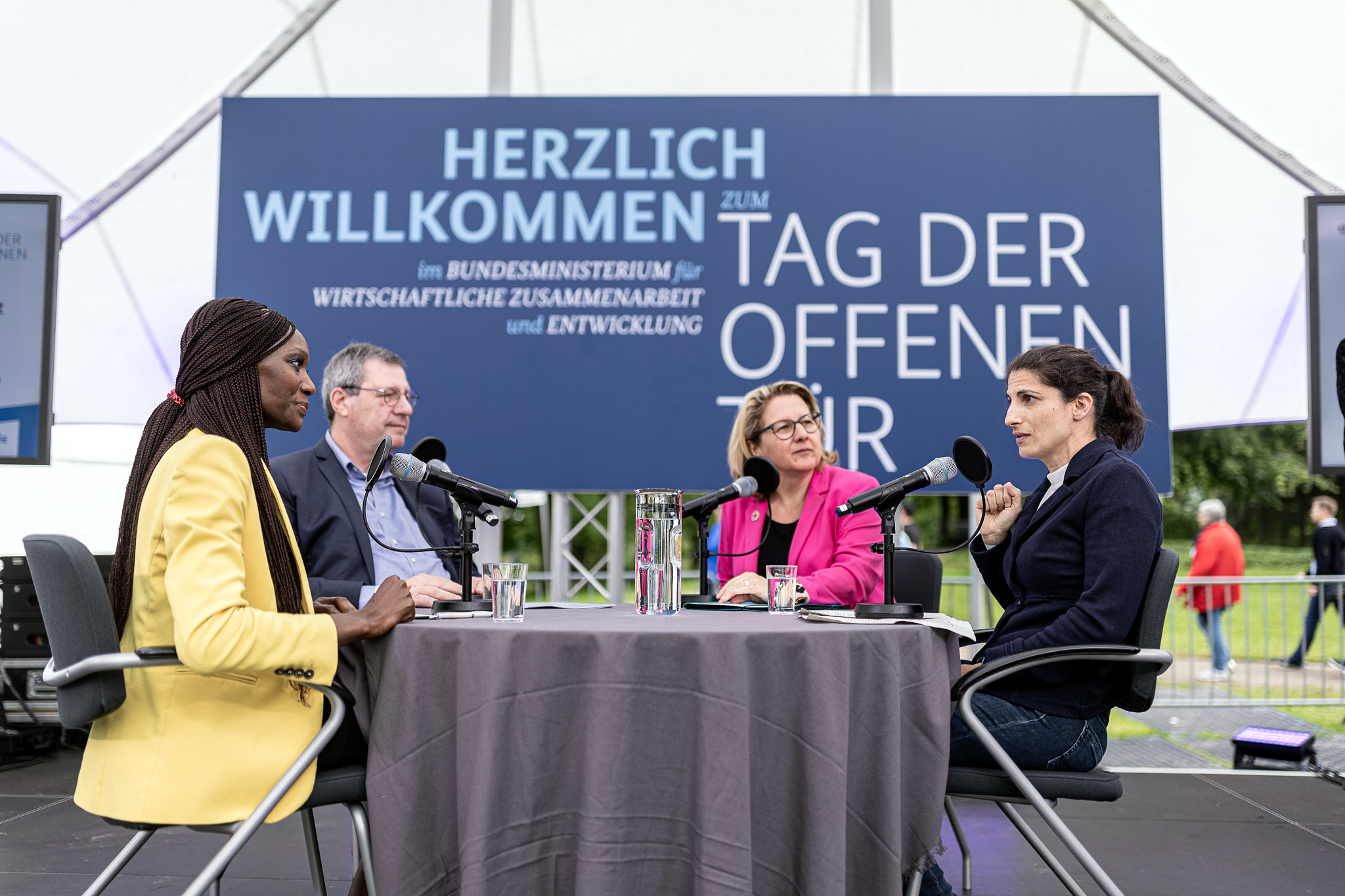 Live-Podcast „Entwicklungssache“ zu Nachhaltigkeit im Fußball und zur EURO2024 mit (von links) Moderatorin Liz Shoo, Werner Wolf (Präsident 1. FC Köln), Bundesentwicklungsministerin Svenja Schulze und Riem Hussein (DFB-Schiedsrichterin) 