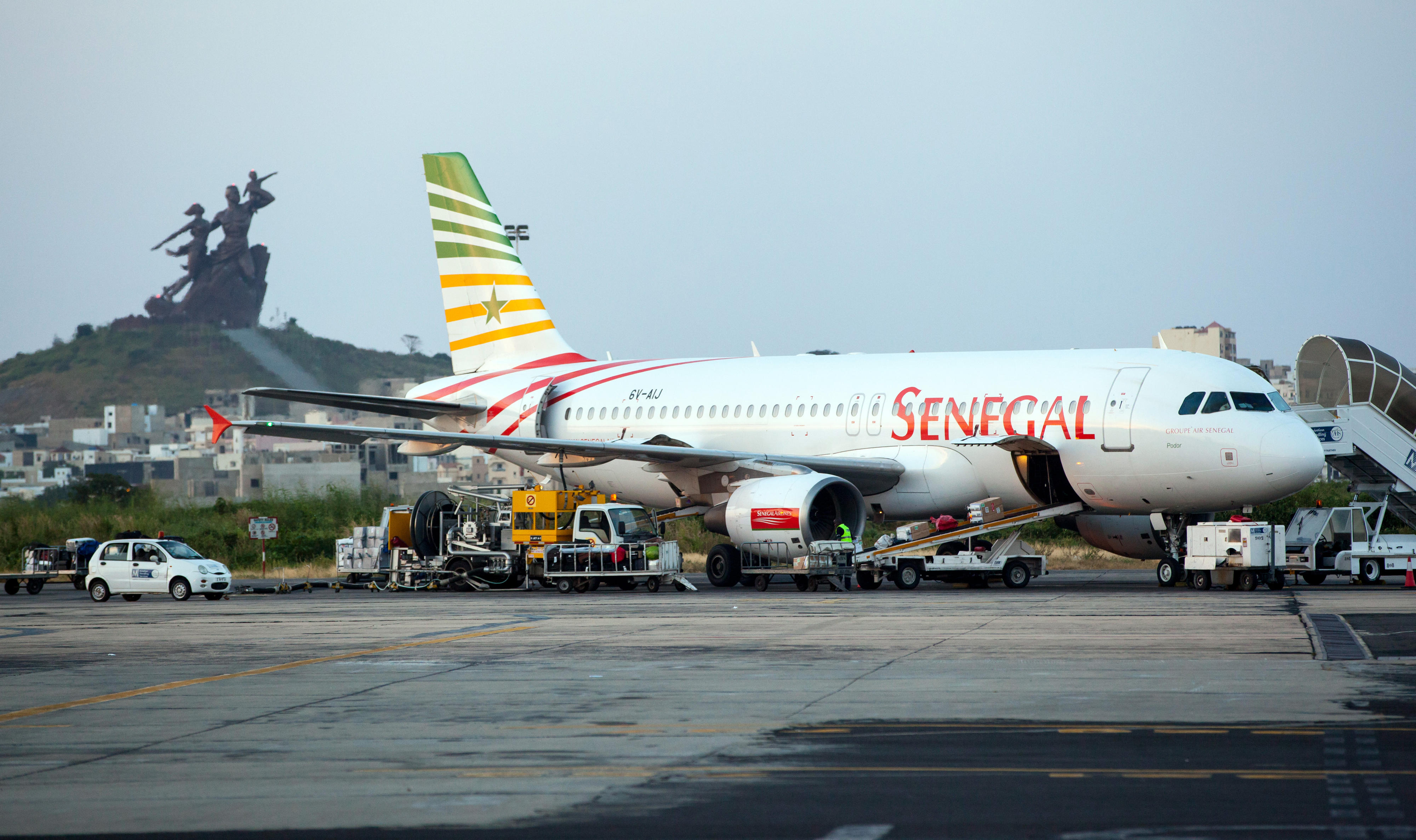 Flugzeug auf dem Leopold-Sedar-Senghor Flughafen in Dakar, Senegal. Im Hintergrund das African Renaissance Monument.