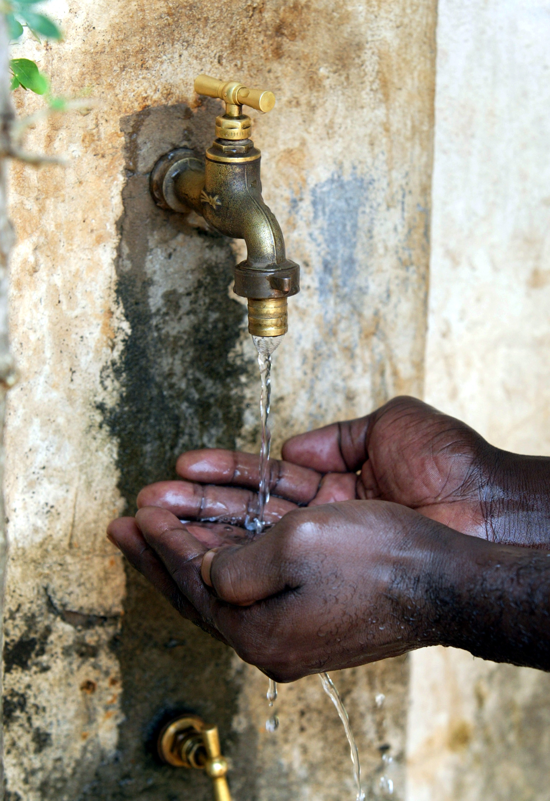 Hände unter einem Wasserhahn in Benin