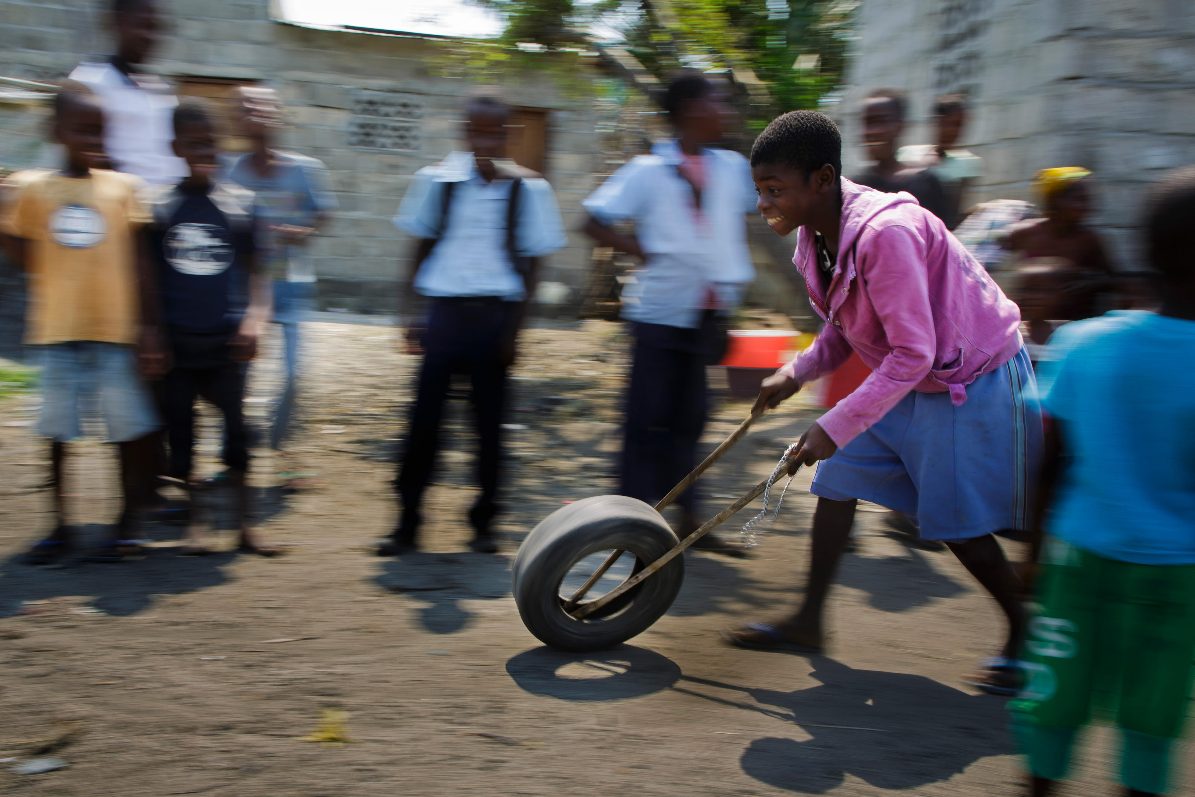 Kinder spielen in einem Slum im Stadtgebiet von Beira mit einem alten Autoreifen.