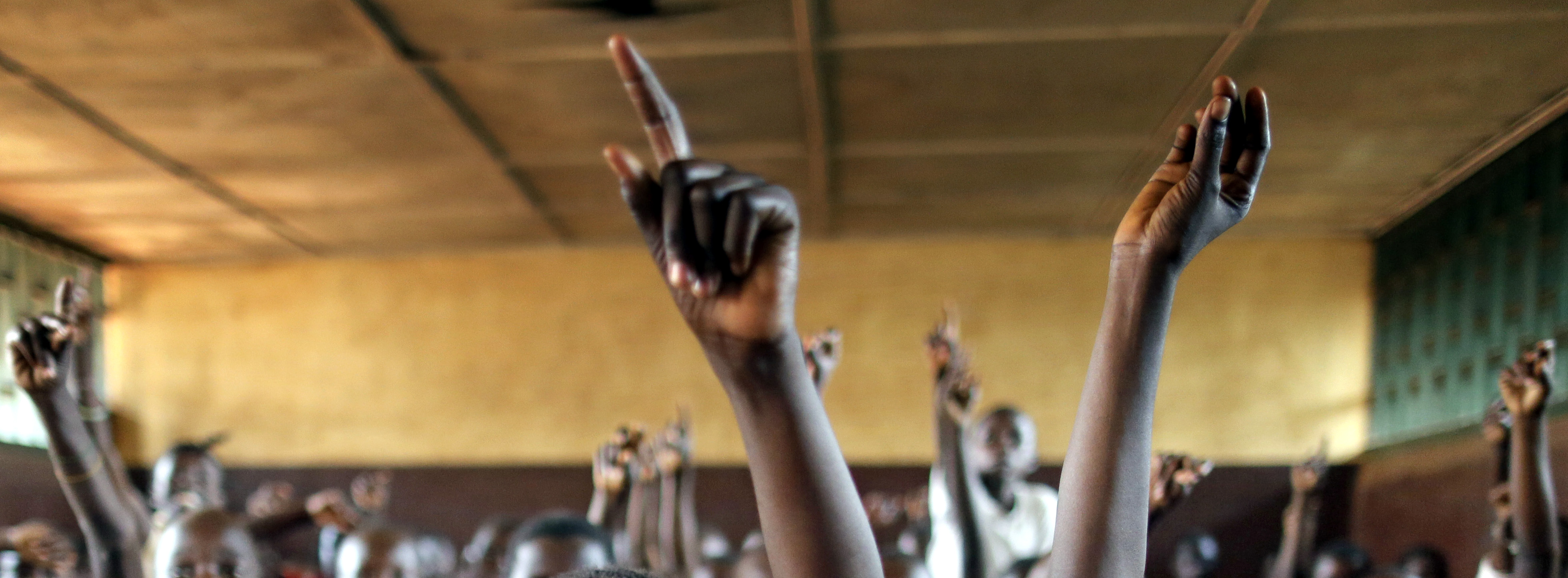 Symbolbild: Schülerinnen und Schüler melde sich im Unterricht durch Heben ihrer Hand