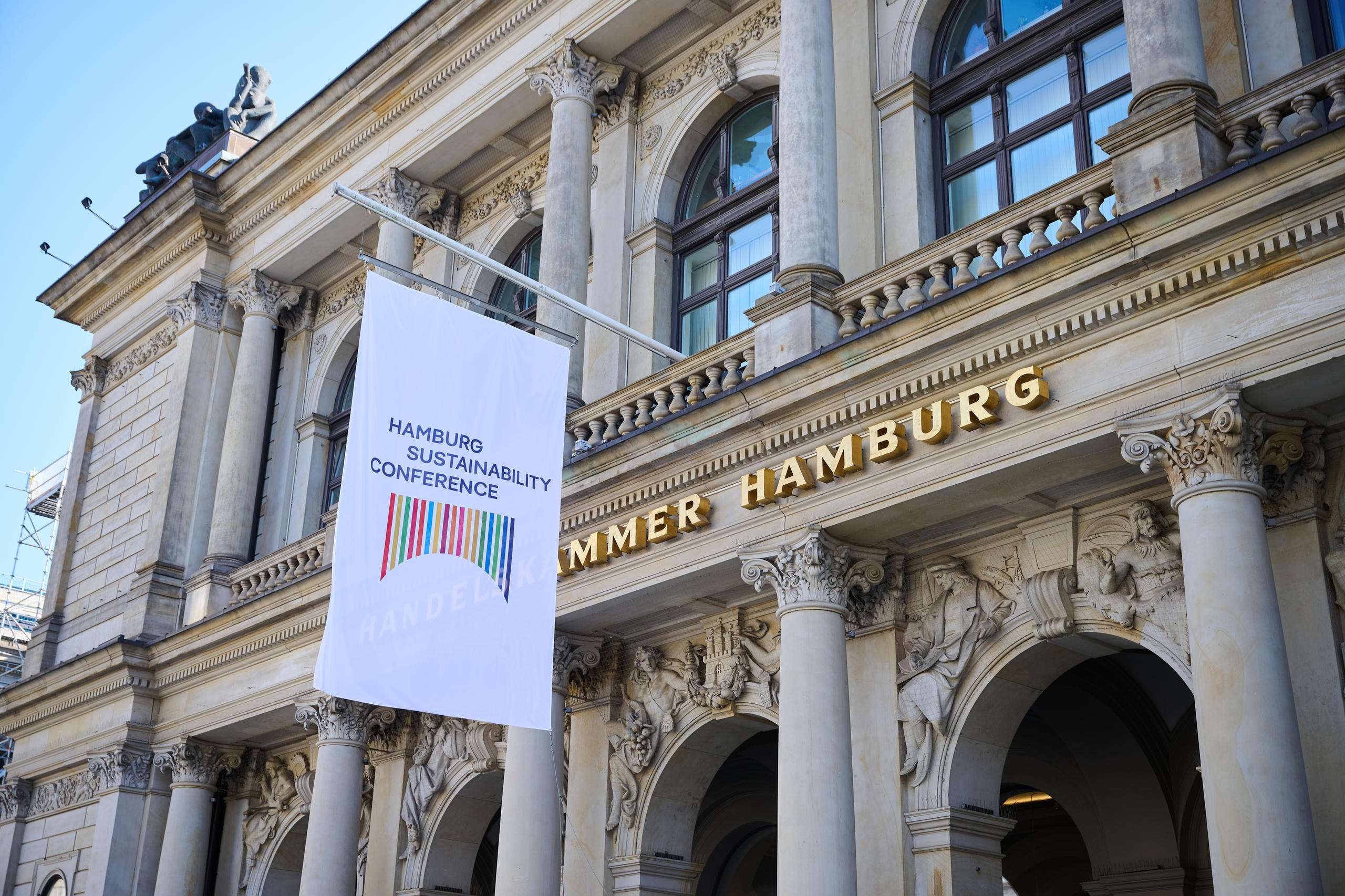 Veranstaltungsort der Hamburger Nachhaltigkeitskonferenz 2025. Eine Fahne mit dem Logo der Konferenz hängt an einem klassizistischen Gebäude.