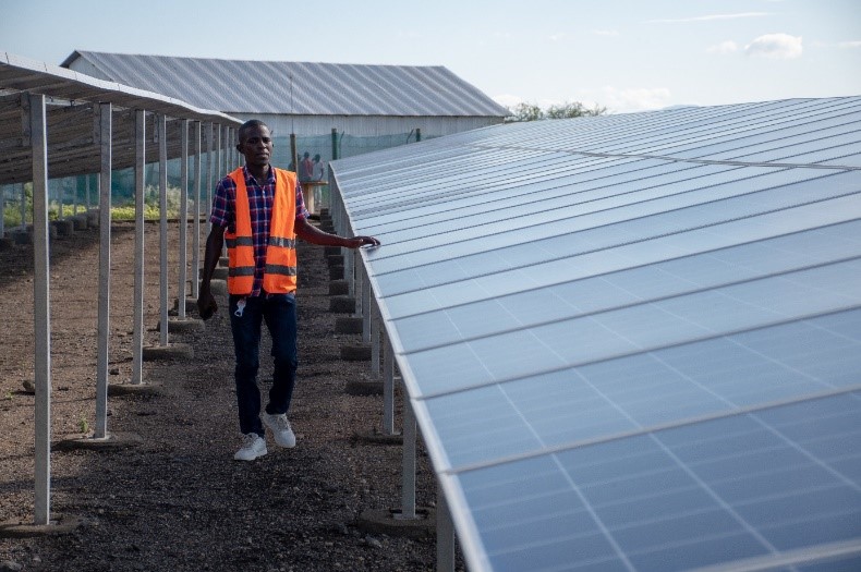 Ein Mann läuft die solare Mini-Grid-Anlage im Kalobeyei Refugee Camp entlang, die während des ESDS-Projekts angeschlossen wurde. 