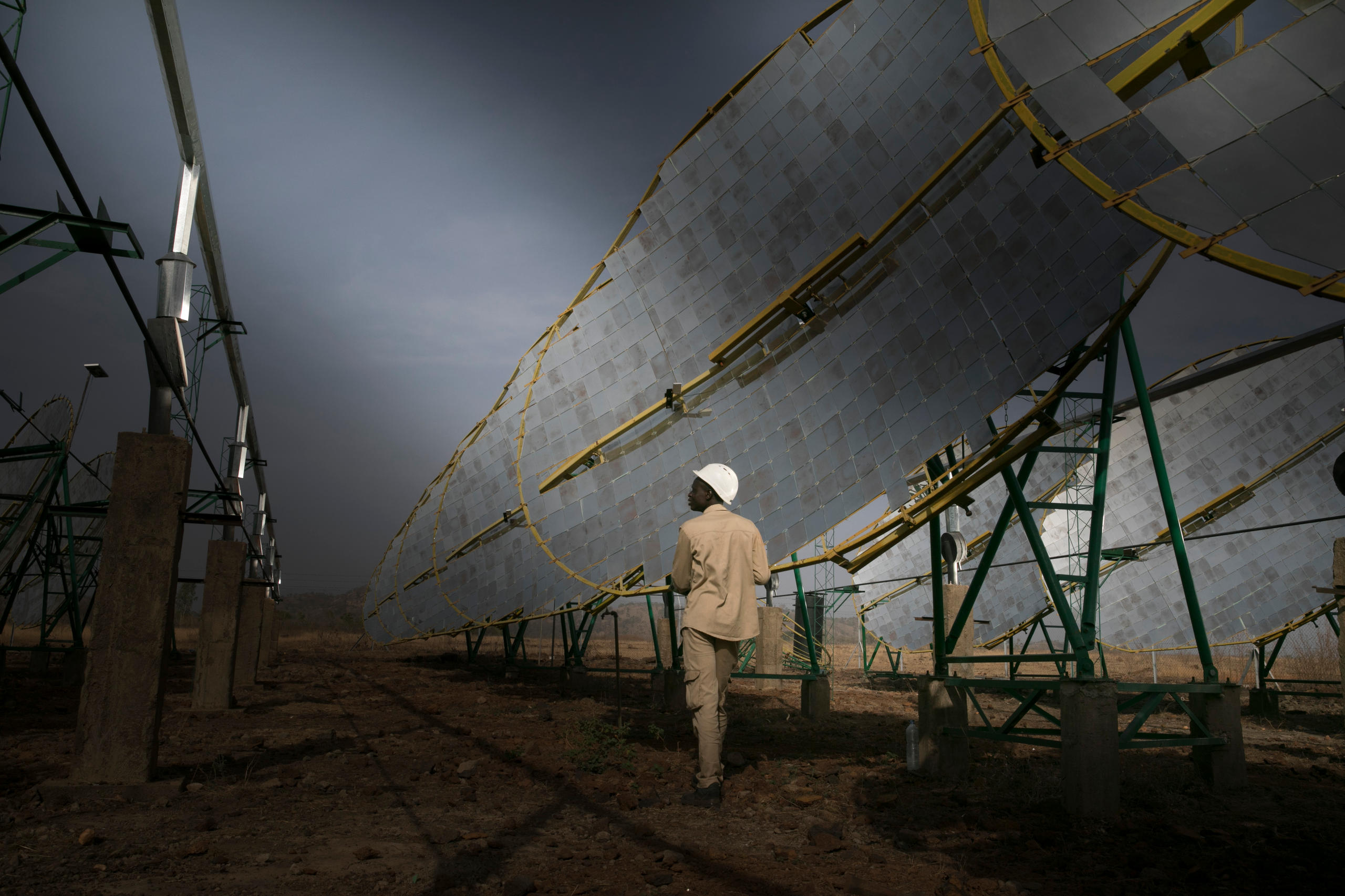 Ein Mann steht mit einem Helm vor einer großen Wand Spiegel