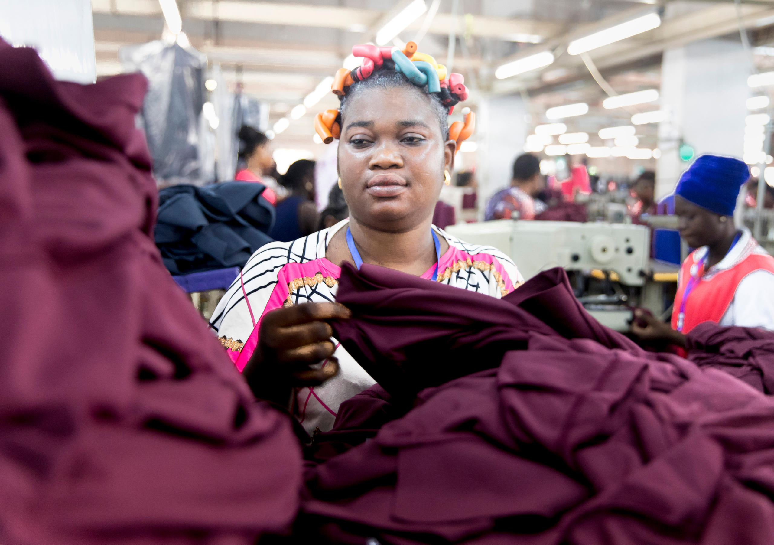 Foto von einer Frau, die mit Stoffen hantiert.