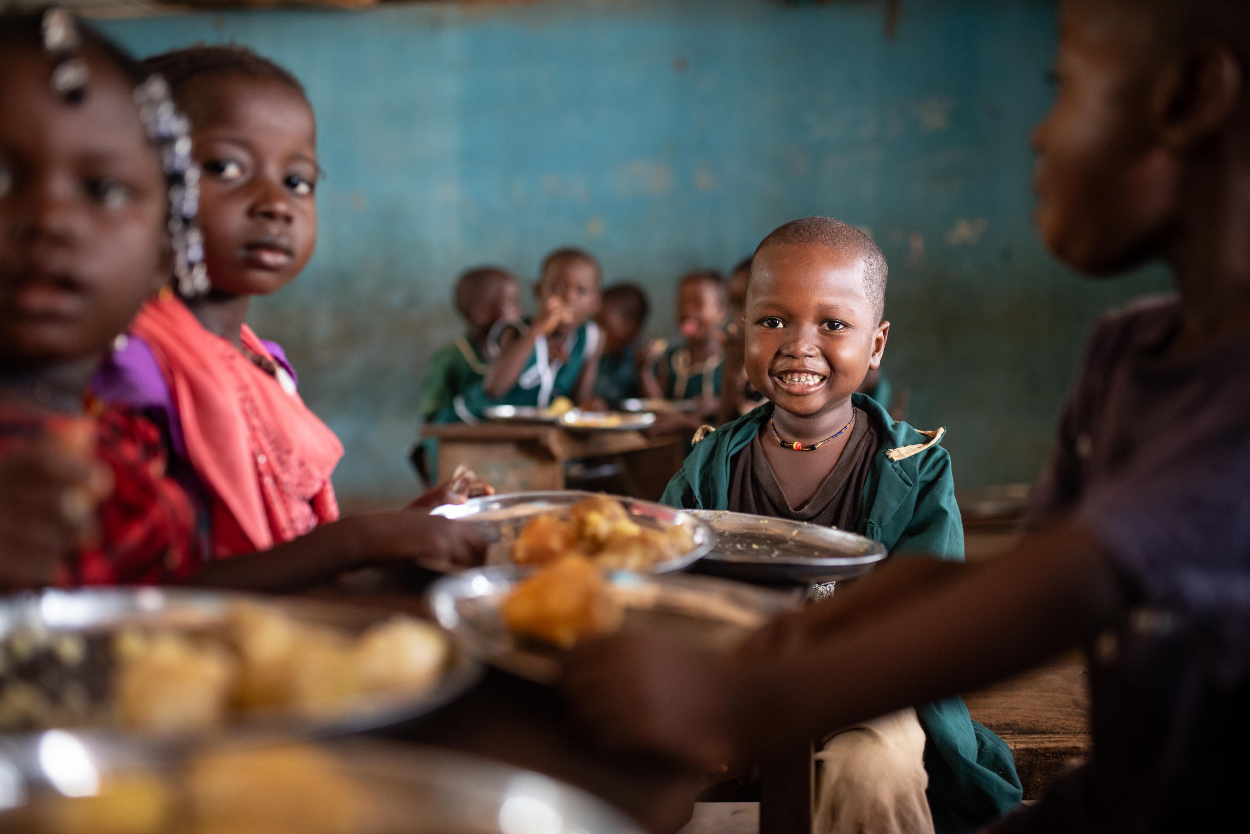 Ein kleiner Junge ist in Sierra Leone an einem Tisch mit anderen Kindern