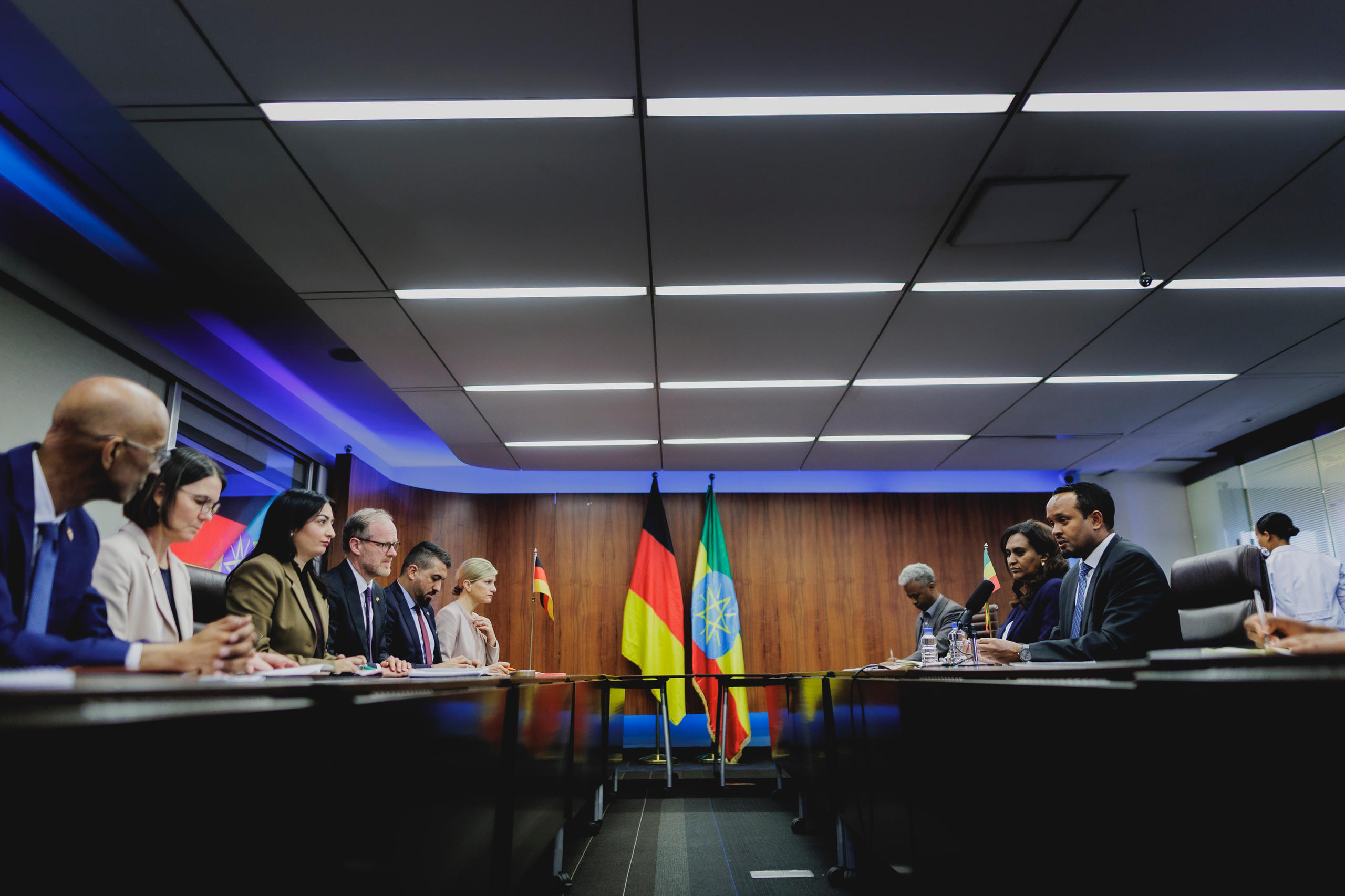 Foto von mehreren Menschen in einem Behördenraum.