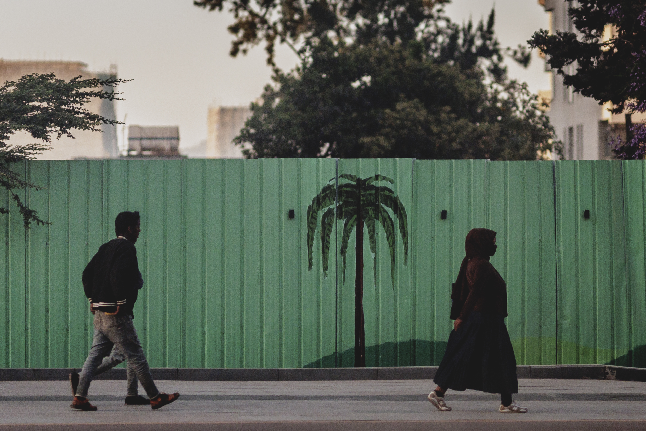Foto von einem Mann und einer Frau, die auf dem Bürgersteig laufen.