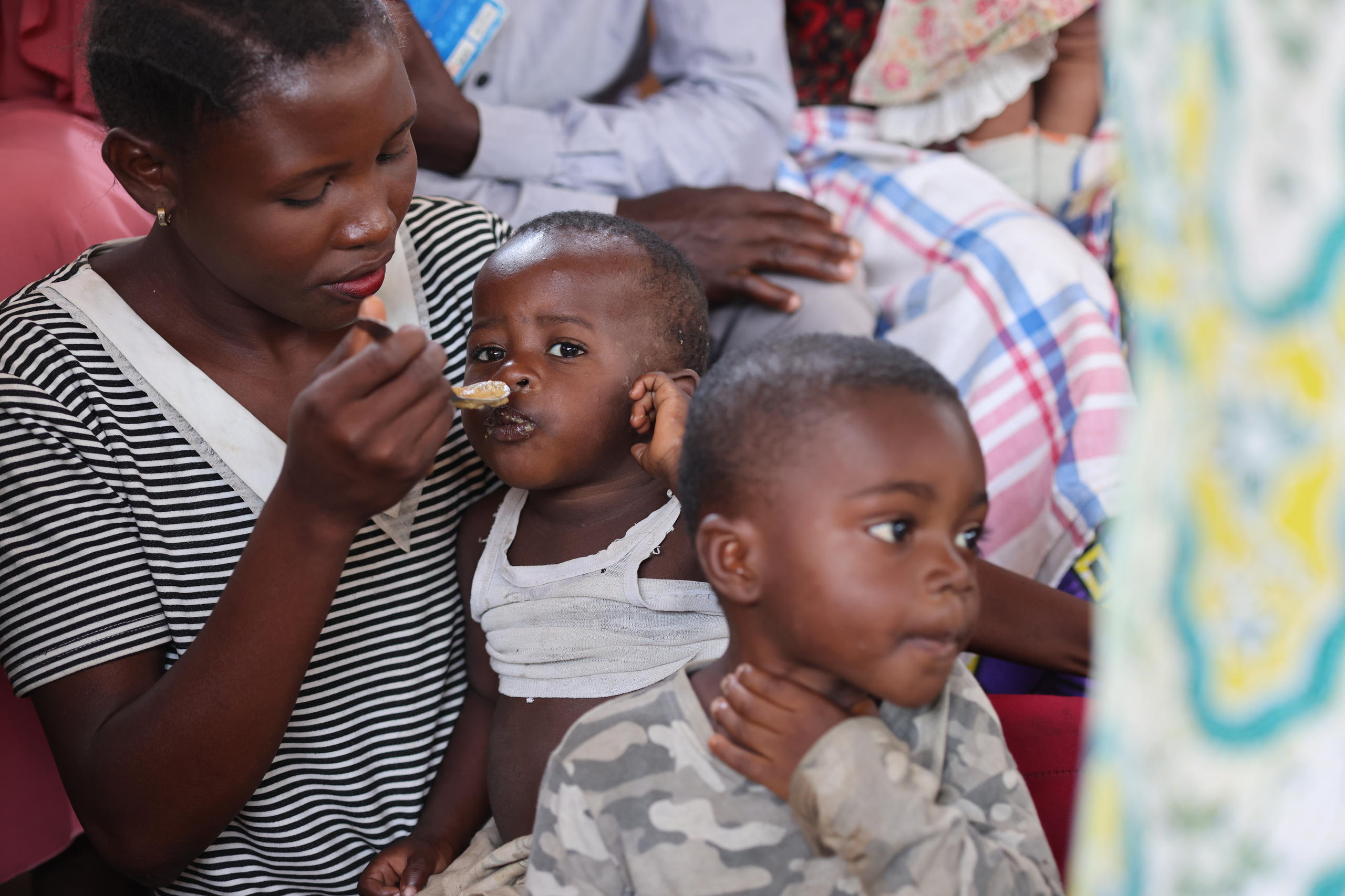 Foto von einer Mutter, die ihr Kind mit einem Löffel füttert.