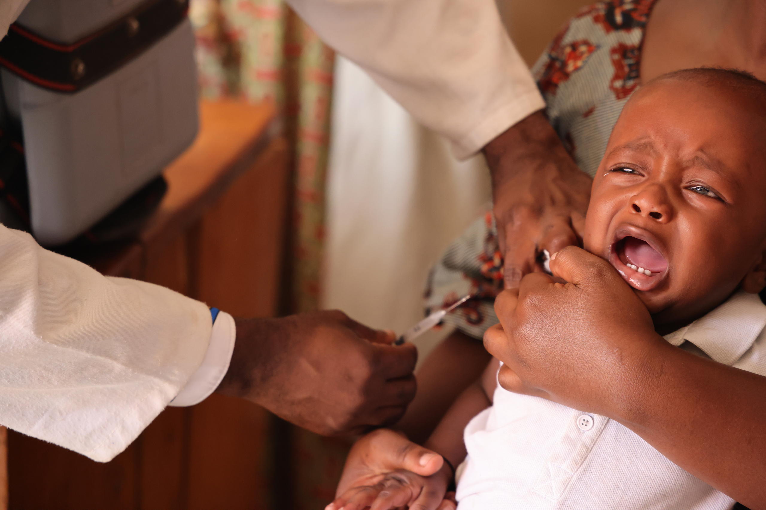 Foto von einem Kleinkind, das eine Spritze in den Arm bekommt.