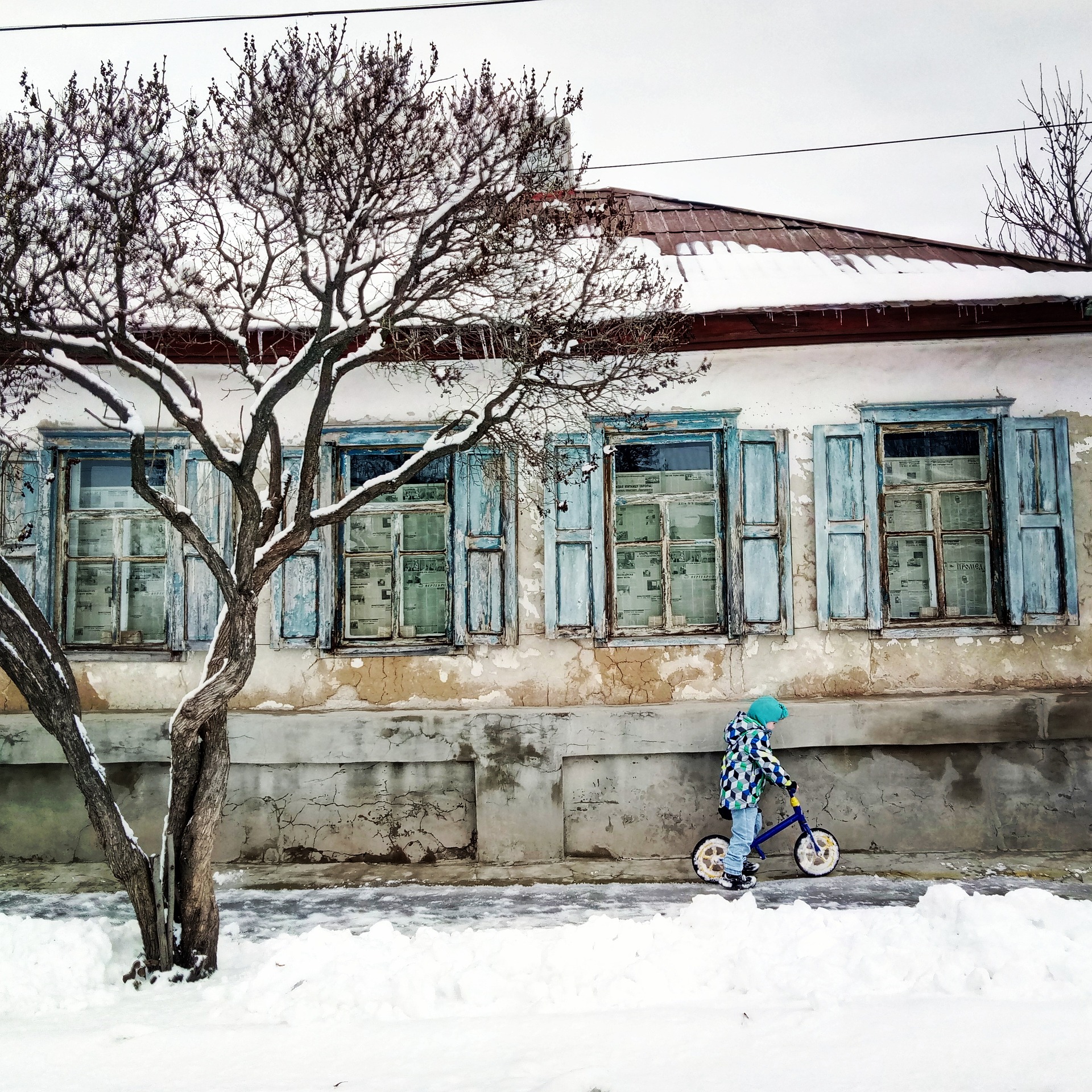 Ein kleiner Junge mit einem Fahrrad in der Ukraine im Schnee