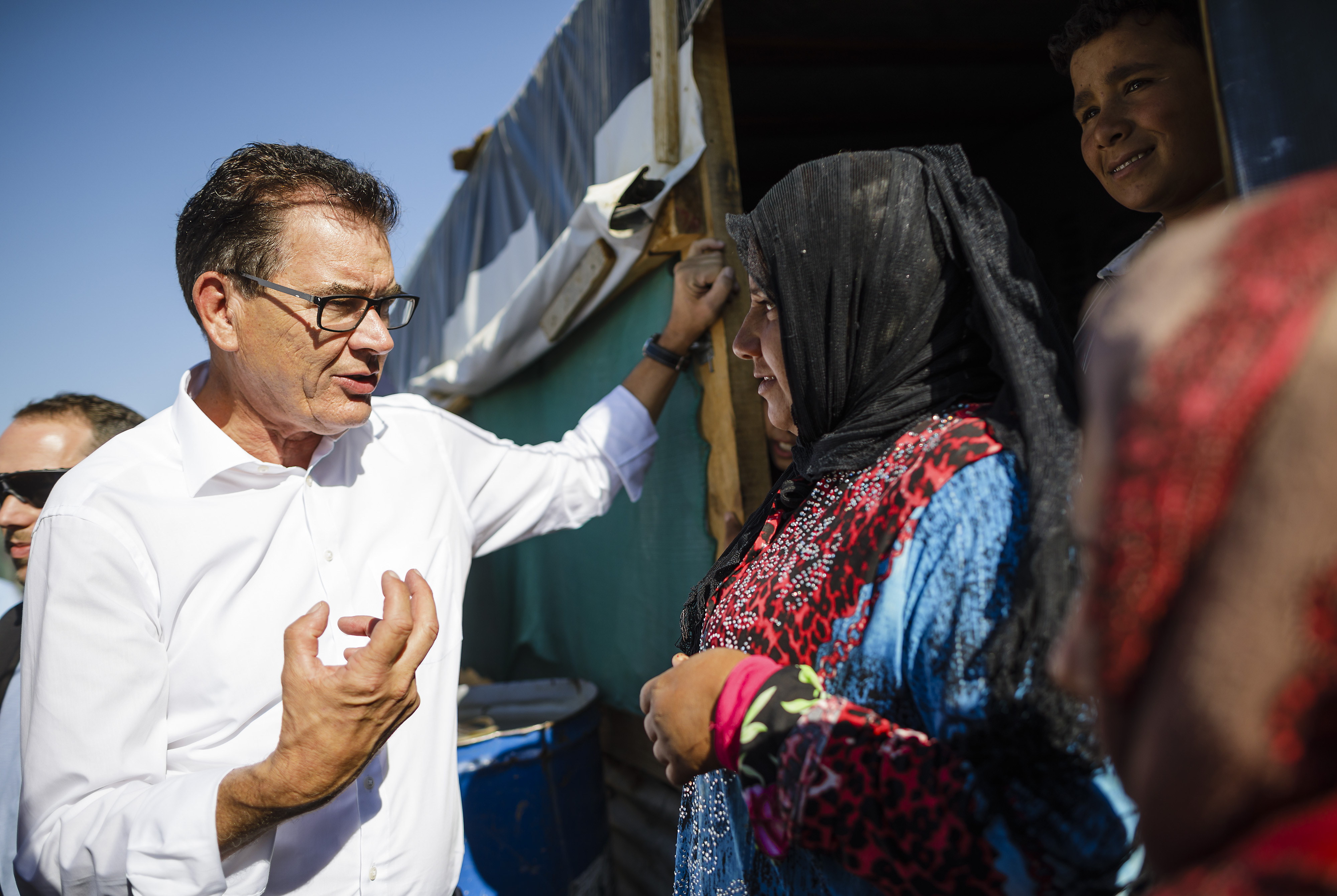 Bundesentwicklungsminister Gerd Müller im Gespräch mit einer Frau beim Besuch eines Flüchtlingslagers in der libanesischen Bekaa Ebene im Oktober 2016