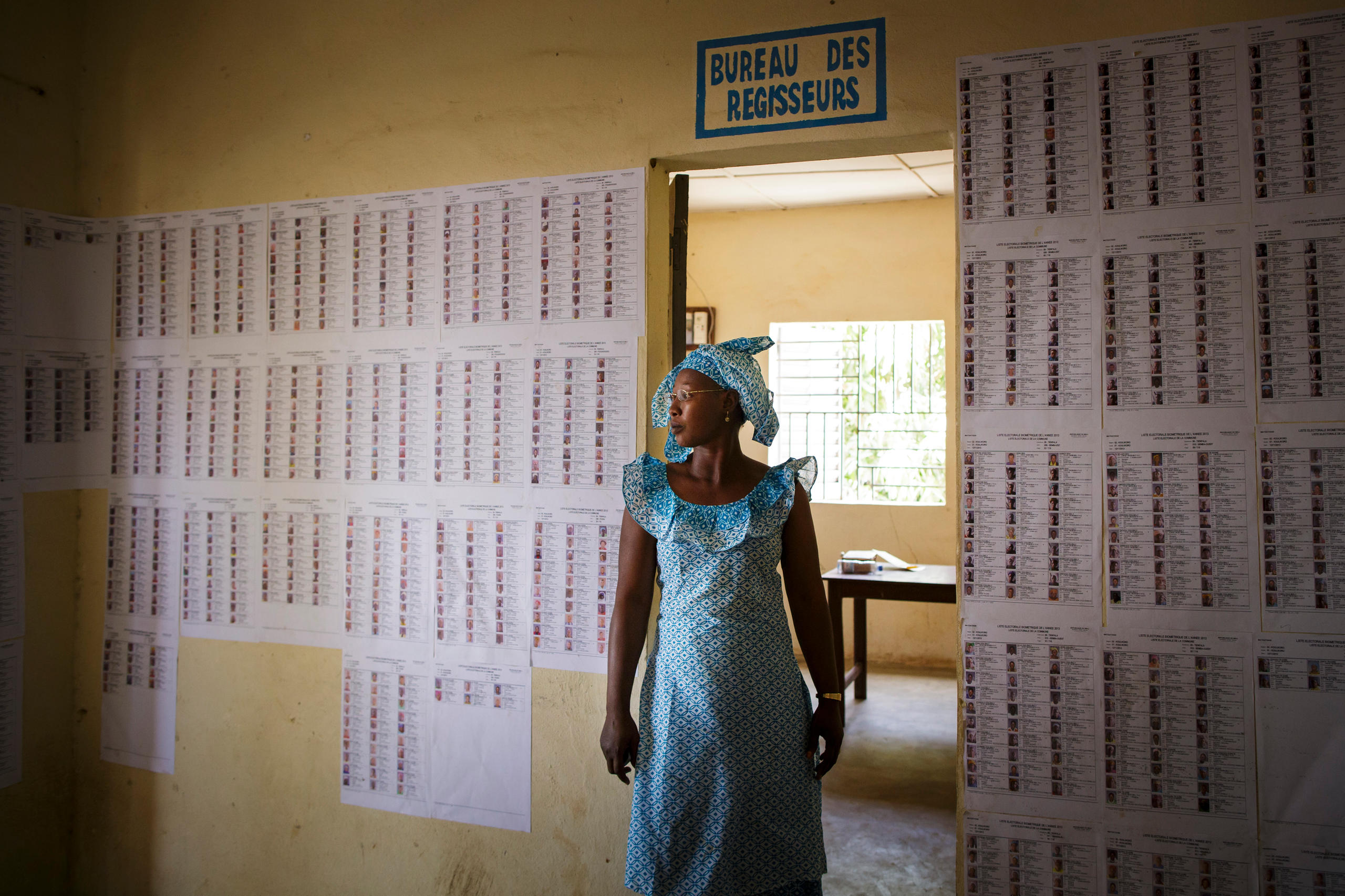 Foto von Frau, die vor einer einer Tür in einem Büro steht.