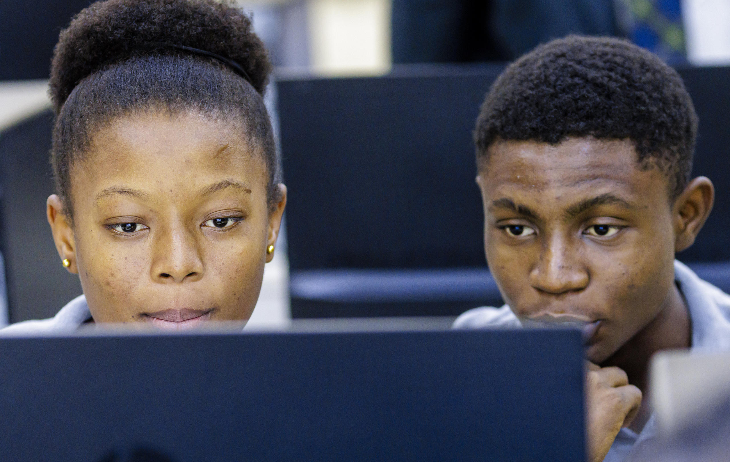 Foto von zwei jungen Menschen, die auf einen Bildschirm schauen.