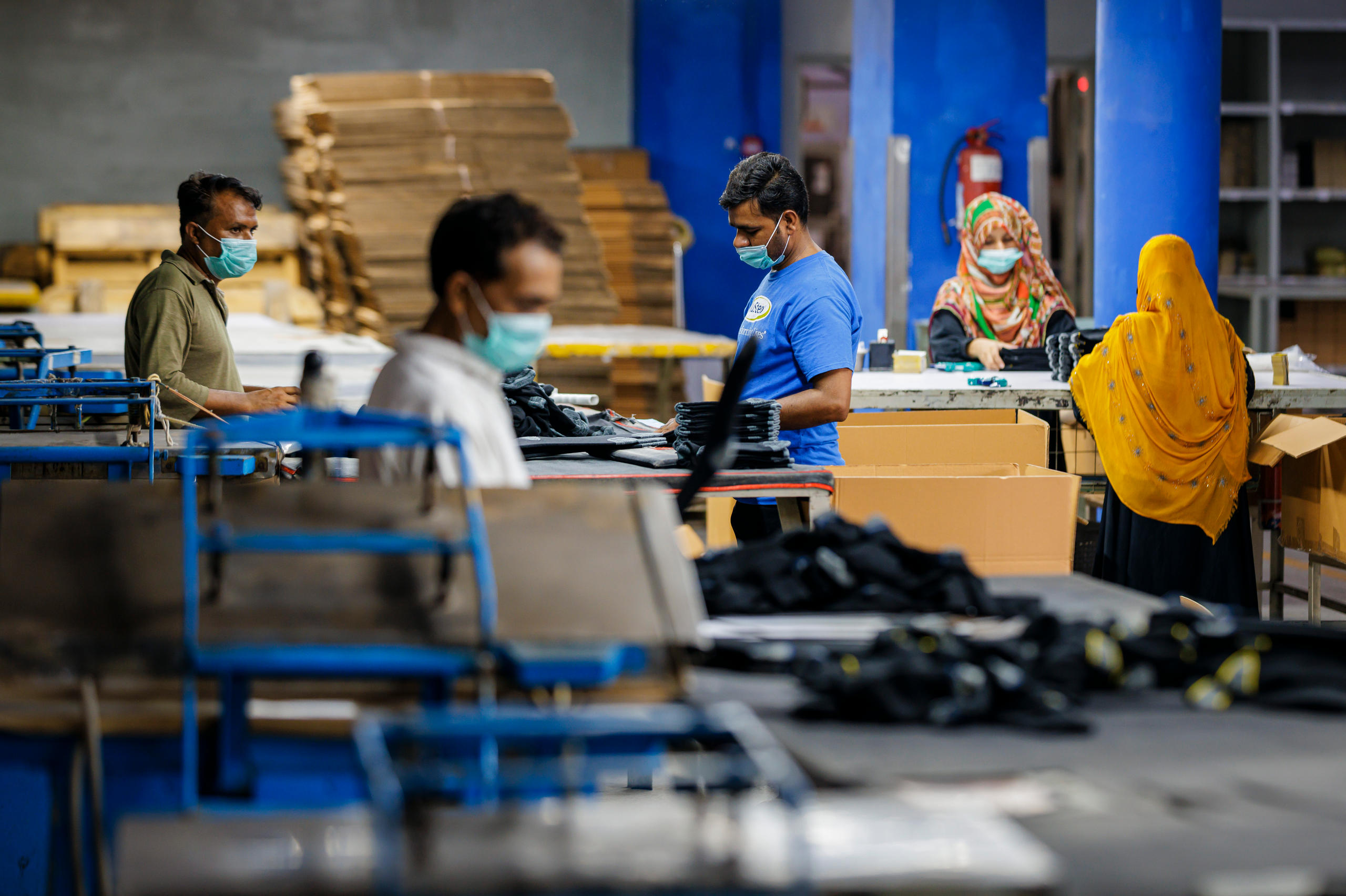 Mitarbeiter und Mitarbeiterinnen eines Textilunternehmens in Pakistan bei der Produktion von Socken.