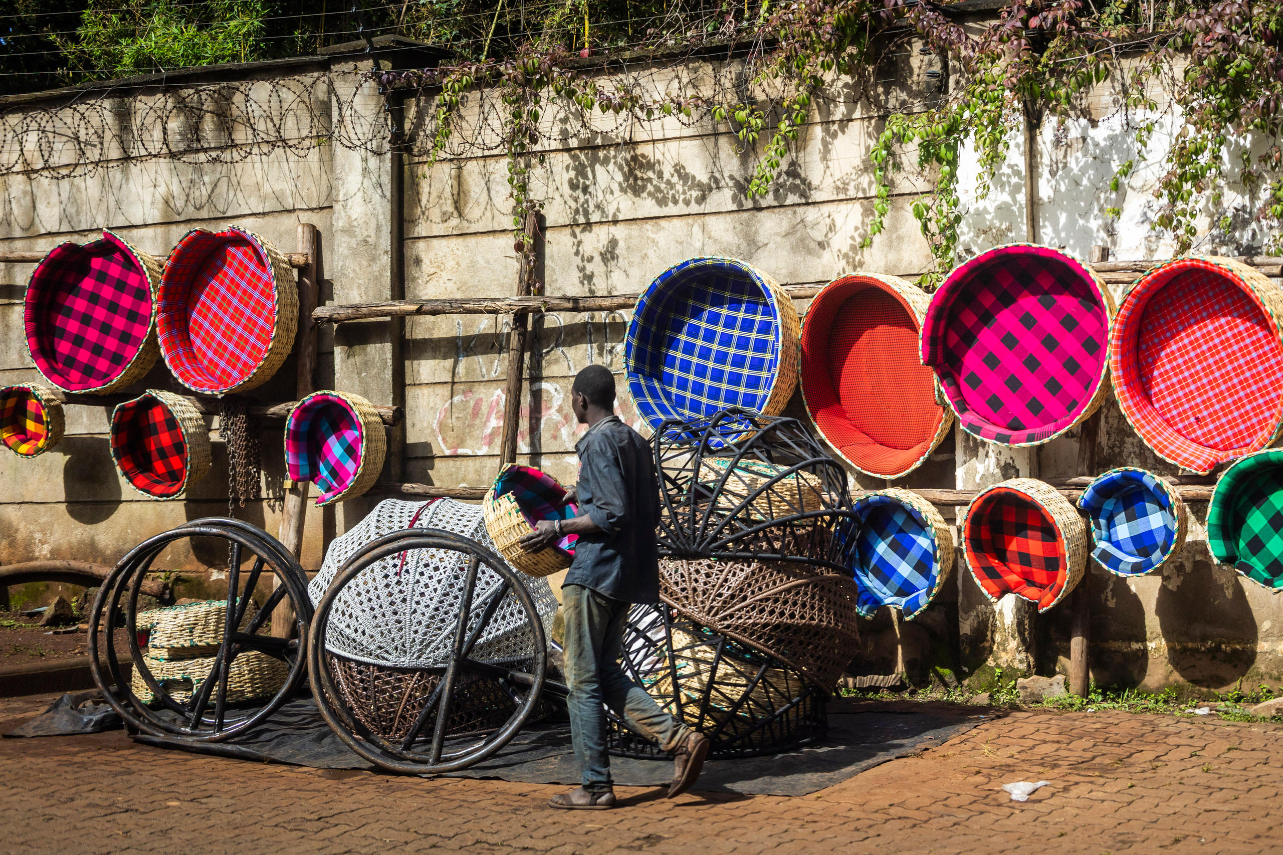 Foto von einem Mann, der riesige, bunte Körbe verkauft.