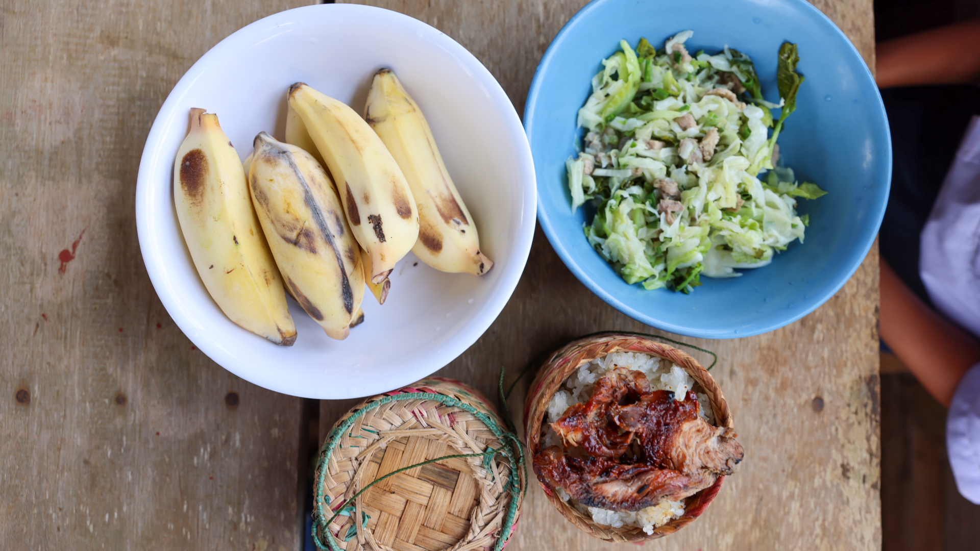 Bananen, Kohl und Reis mit Fleisch in verschiedenen kleinen Tellern. 