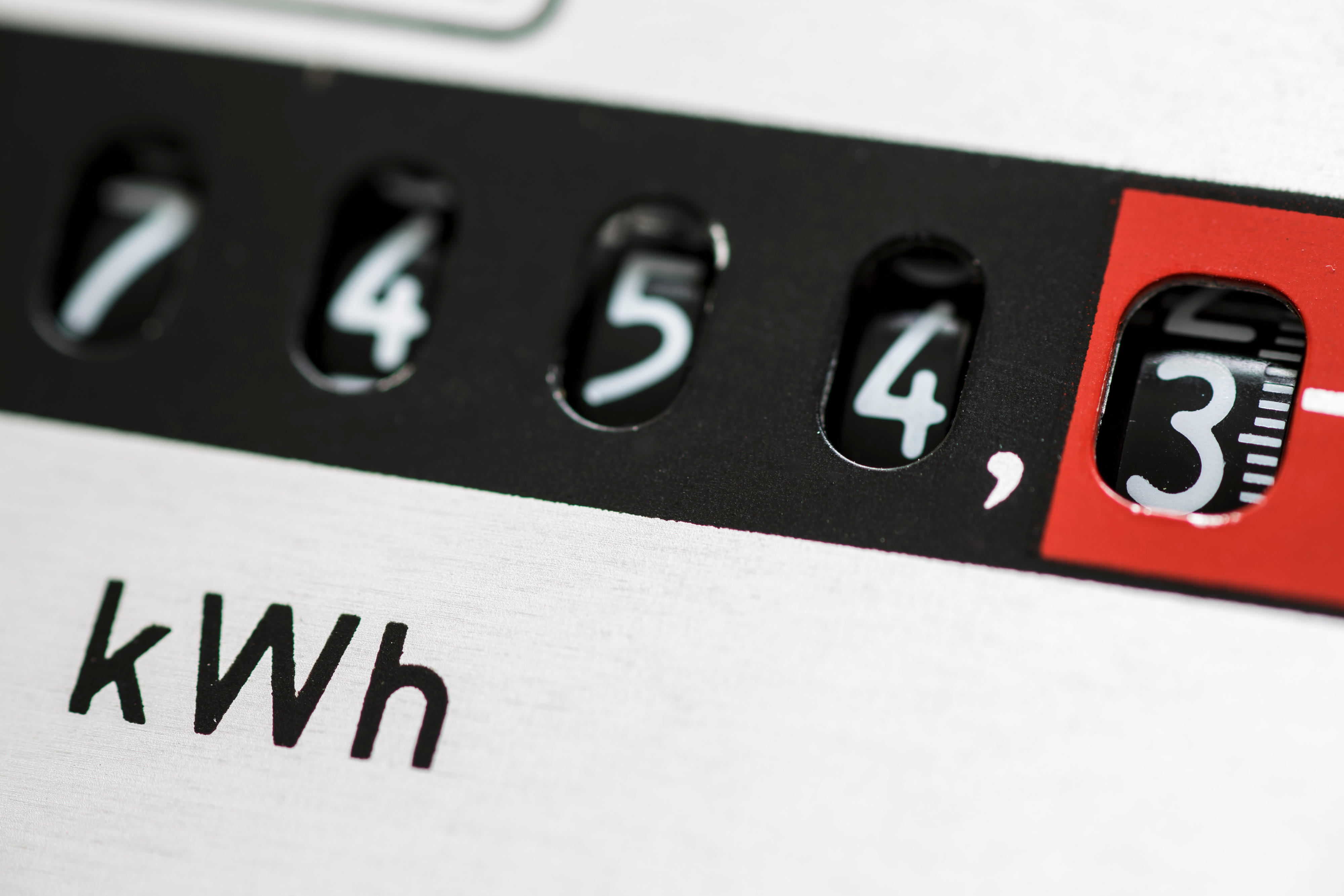 Close-up of an electricity meter showing a reading of 7,454.3 kilowatt-hours