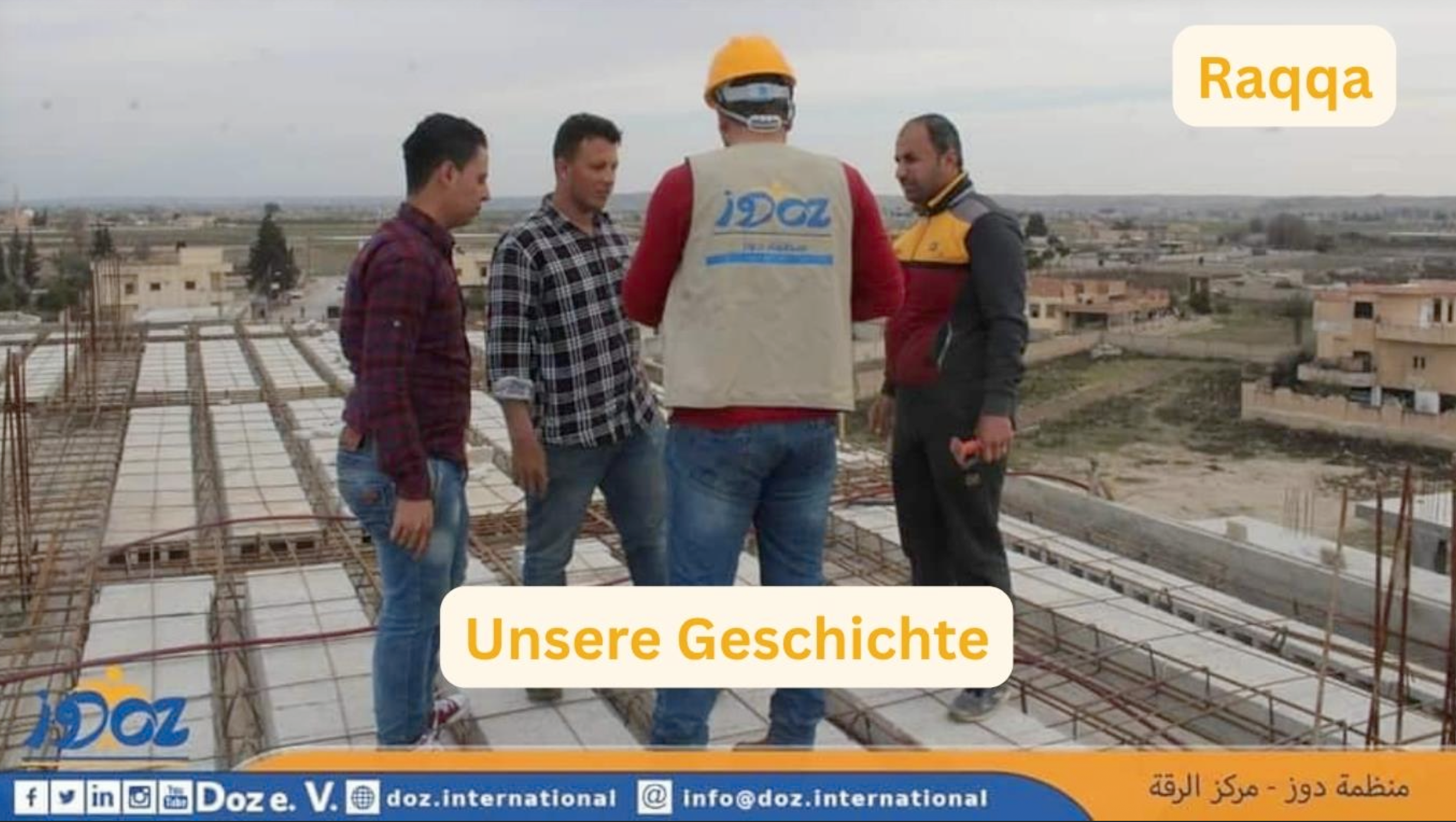 Vier Männer stehen auf einer Baustelle mit Stahlbewehrung, einer trägt einen gelben Helm und eine Weste mit dem Logo 'DOZ'.