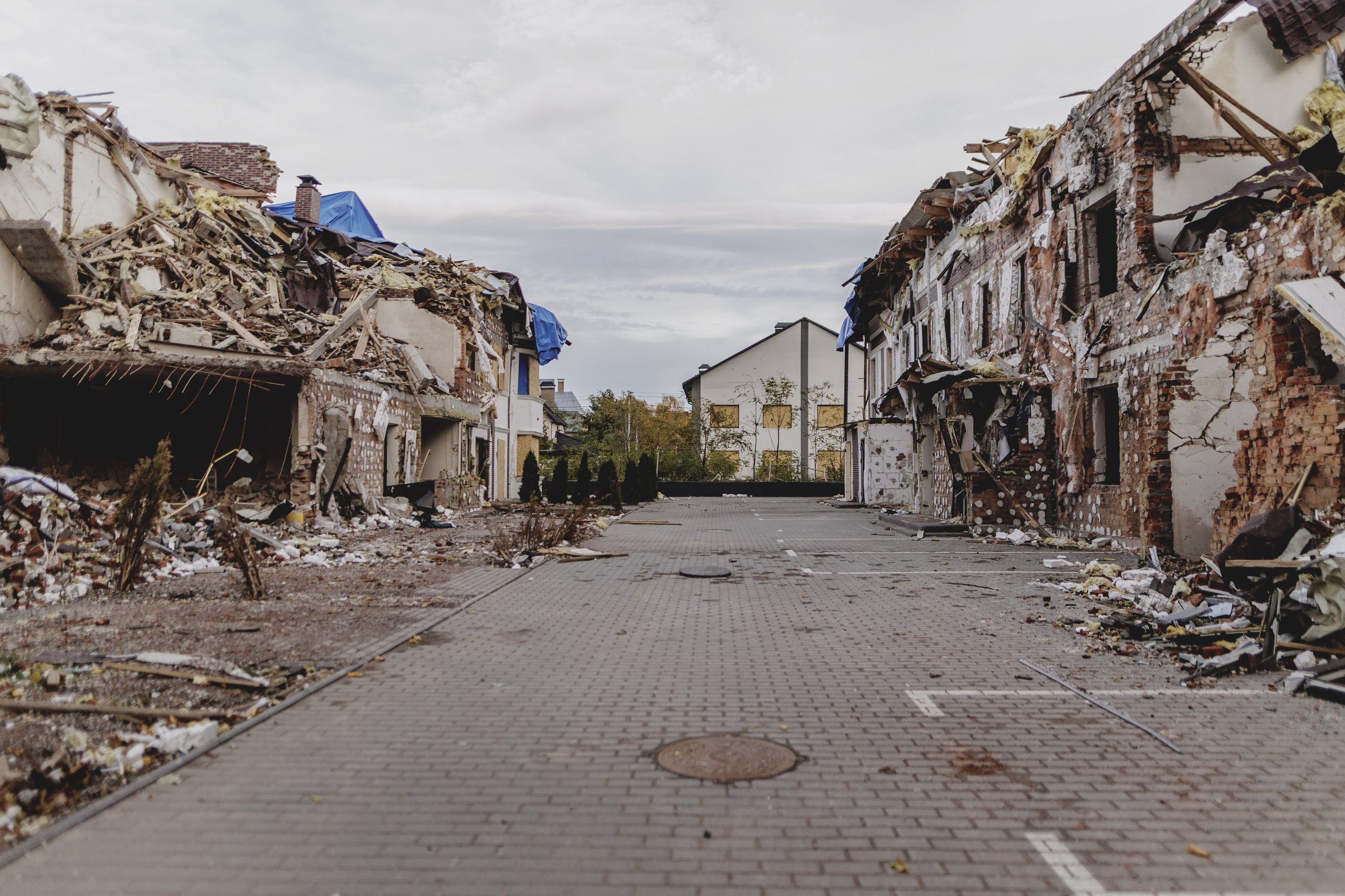 Foto eines Mannes vor einem zerstören Haus.