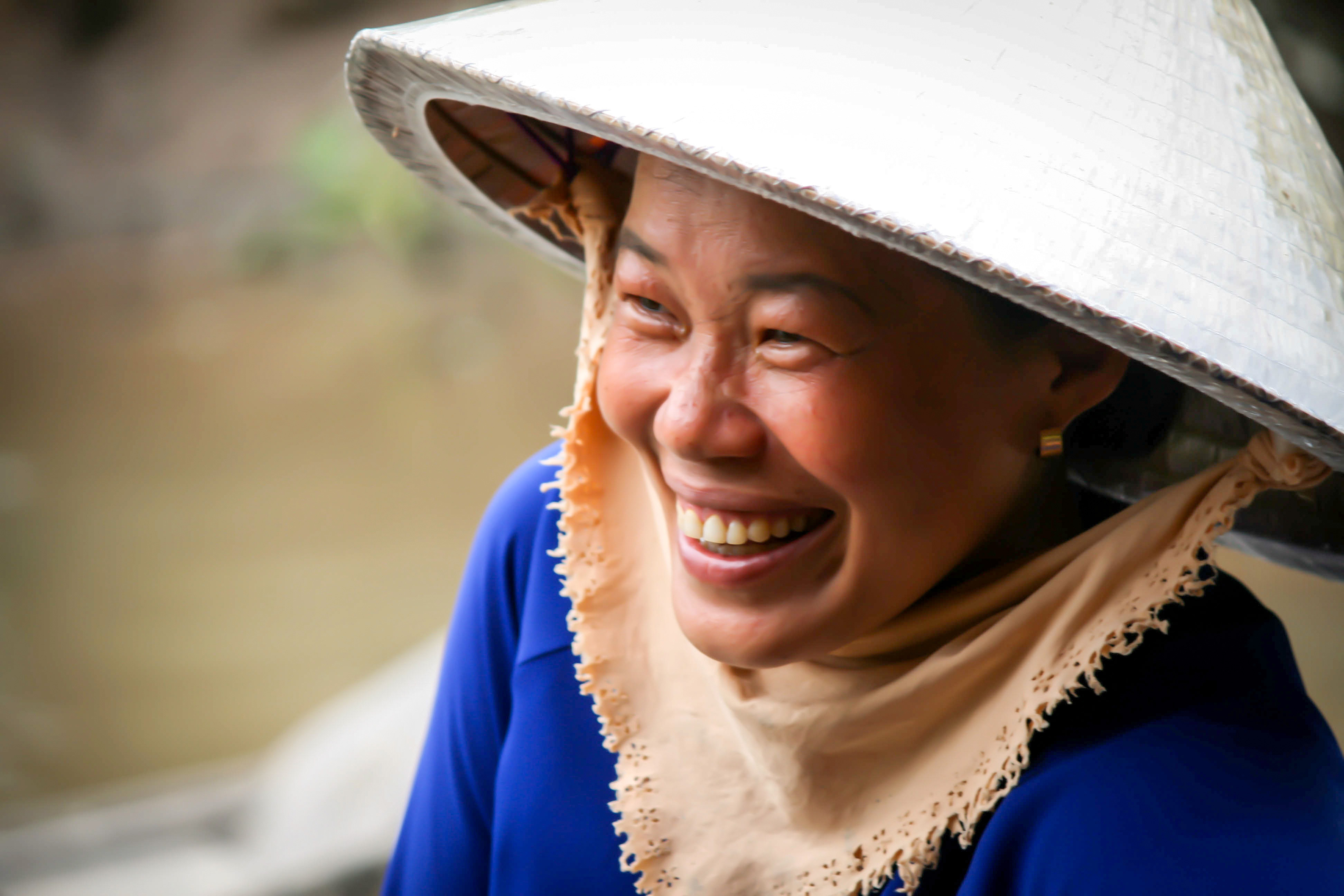 Eine lachende Frau mit Hut in Vietnam